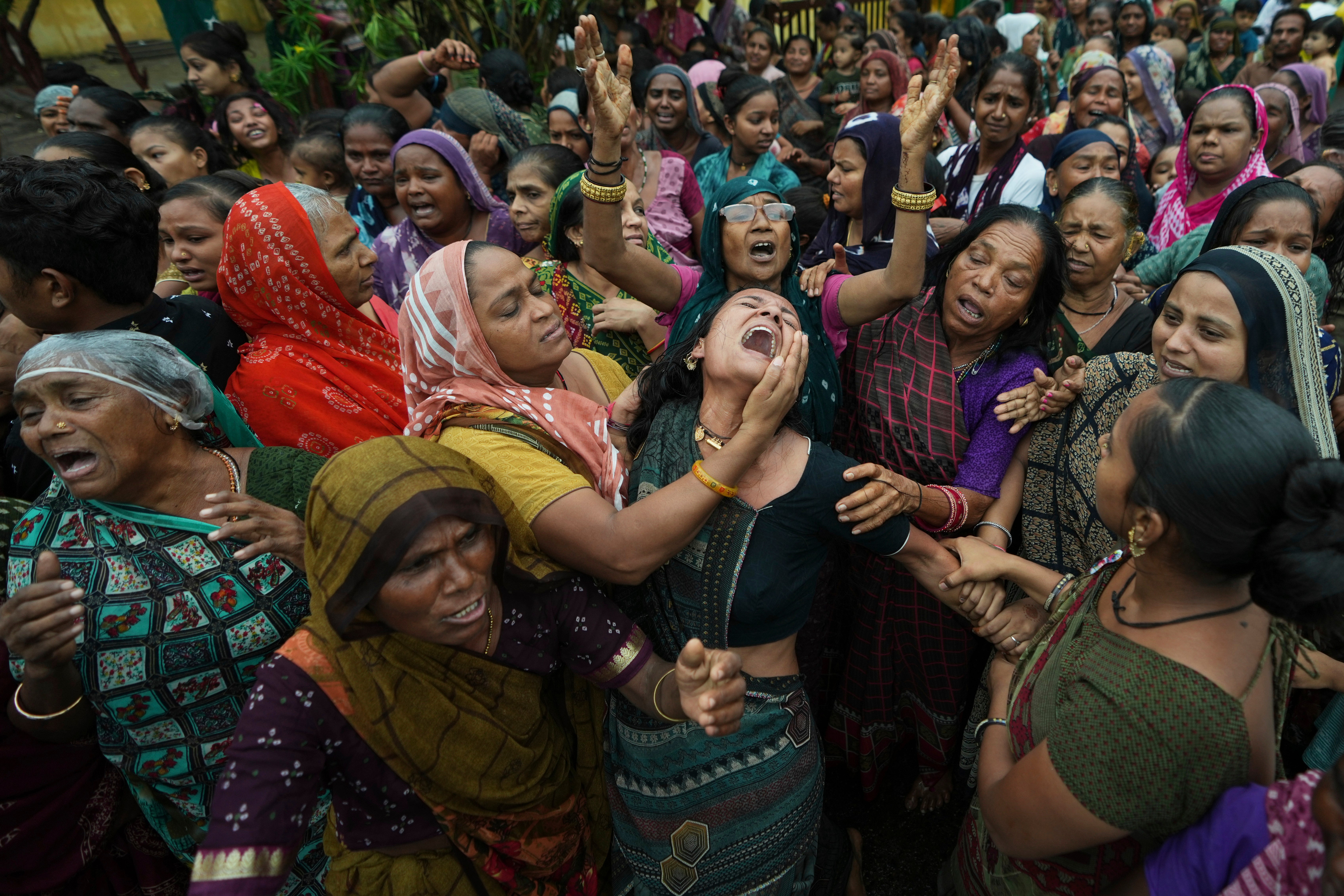 Relatives of Akash Patni, a victim of the Air India crash, grieve during his funeral procession in Ahmedabad