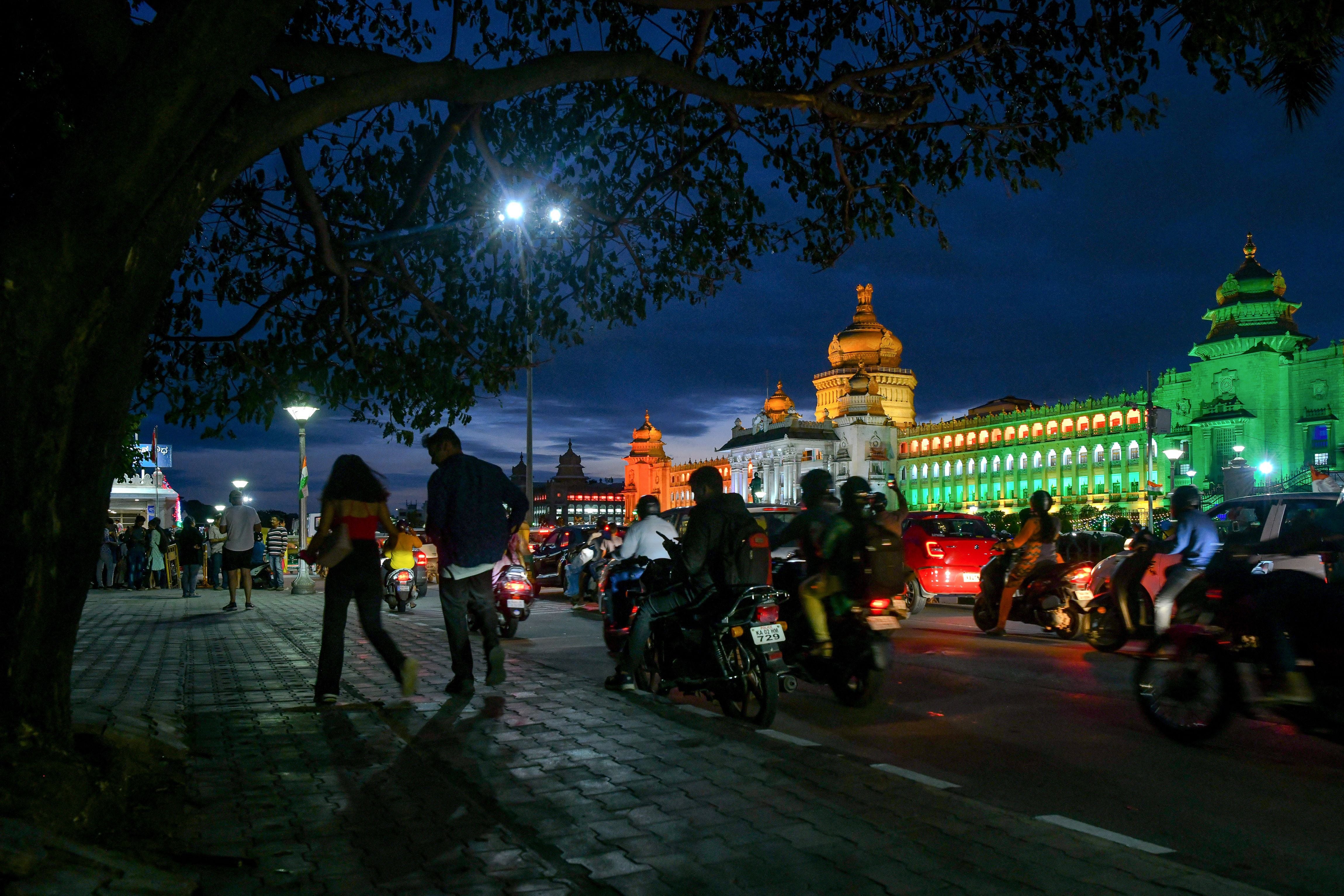 Pedestrians walk in front of the Karnataka state legislature building in Bengaluru
