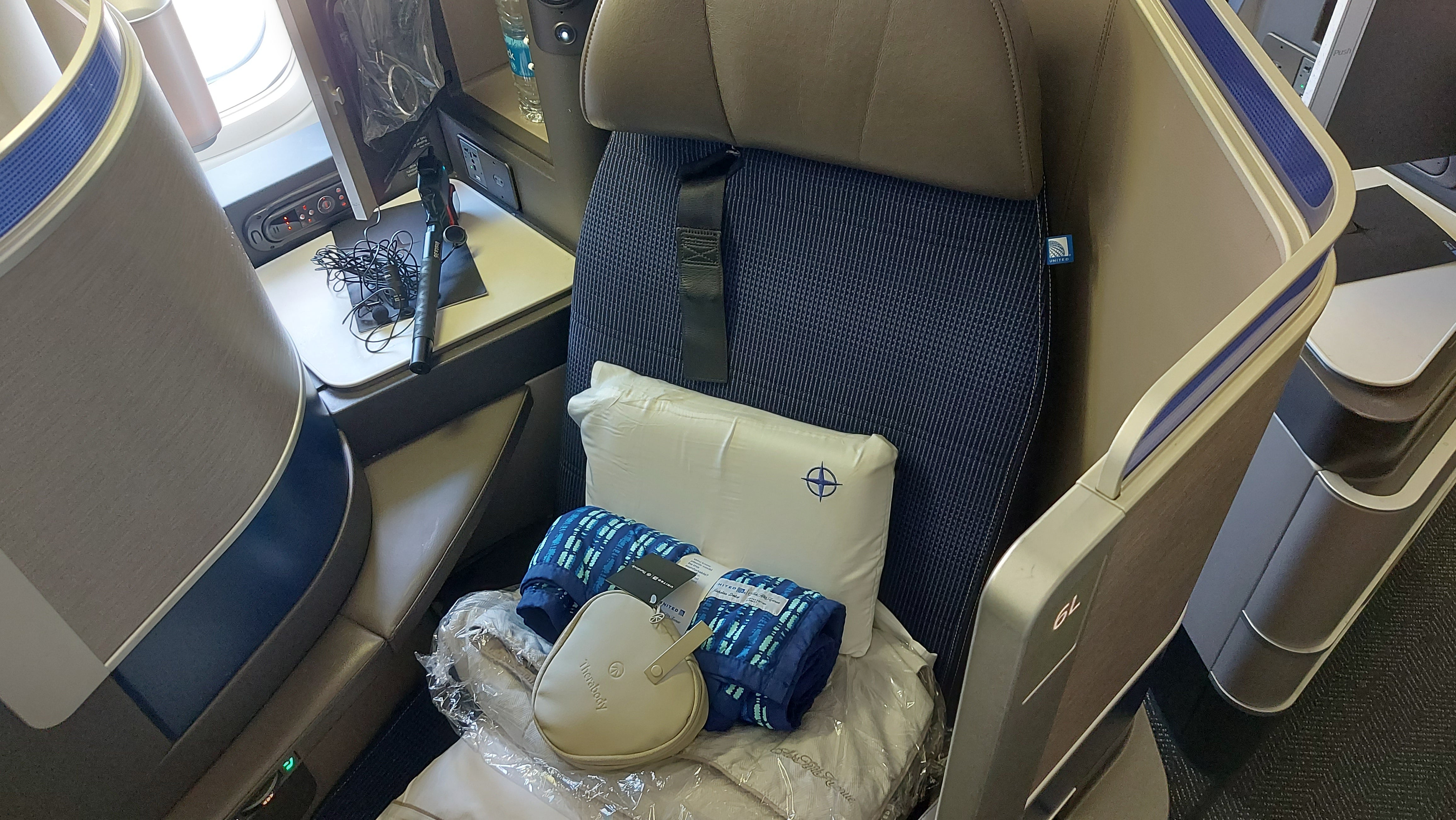 Upon boarding, Ted's seat is piled high with extras - bedding and a blanket by Saks Fifth Avenue and an amenity kit by Therabody