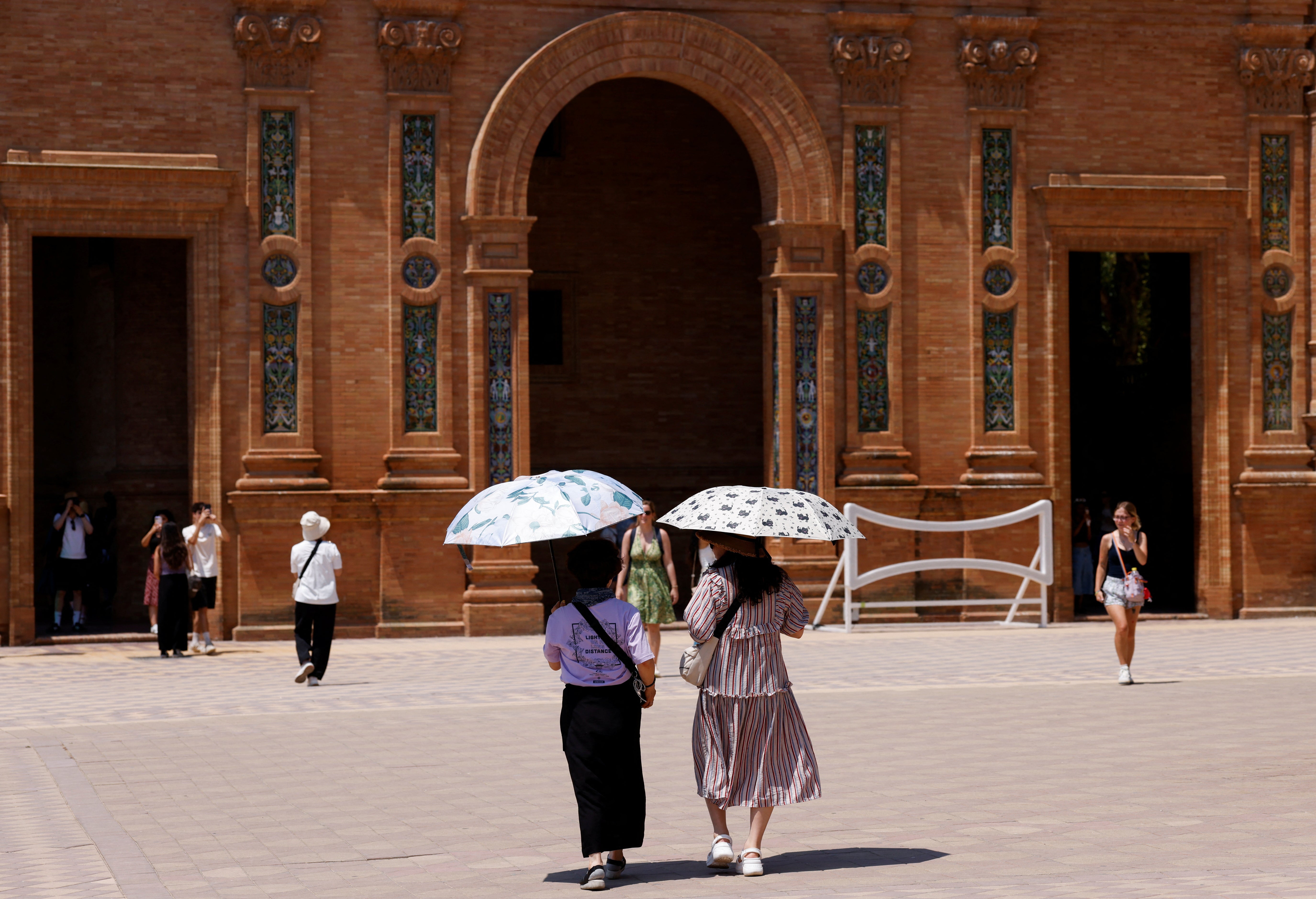 Women use umbrellas to protect themself from the sun during this week’s heatwave in Seville
