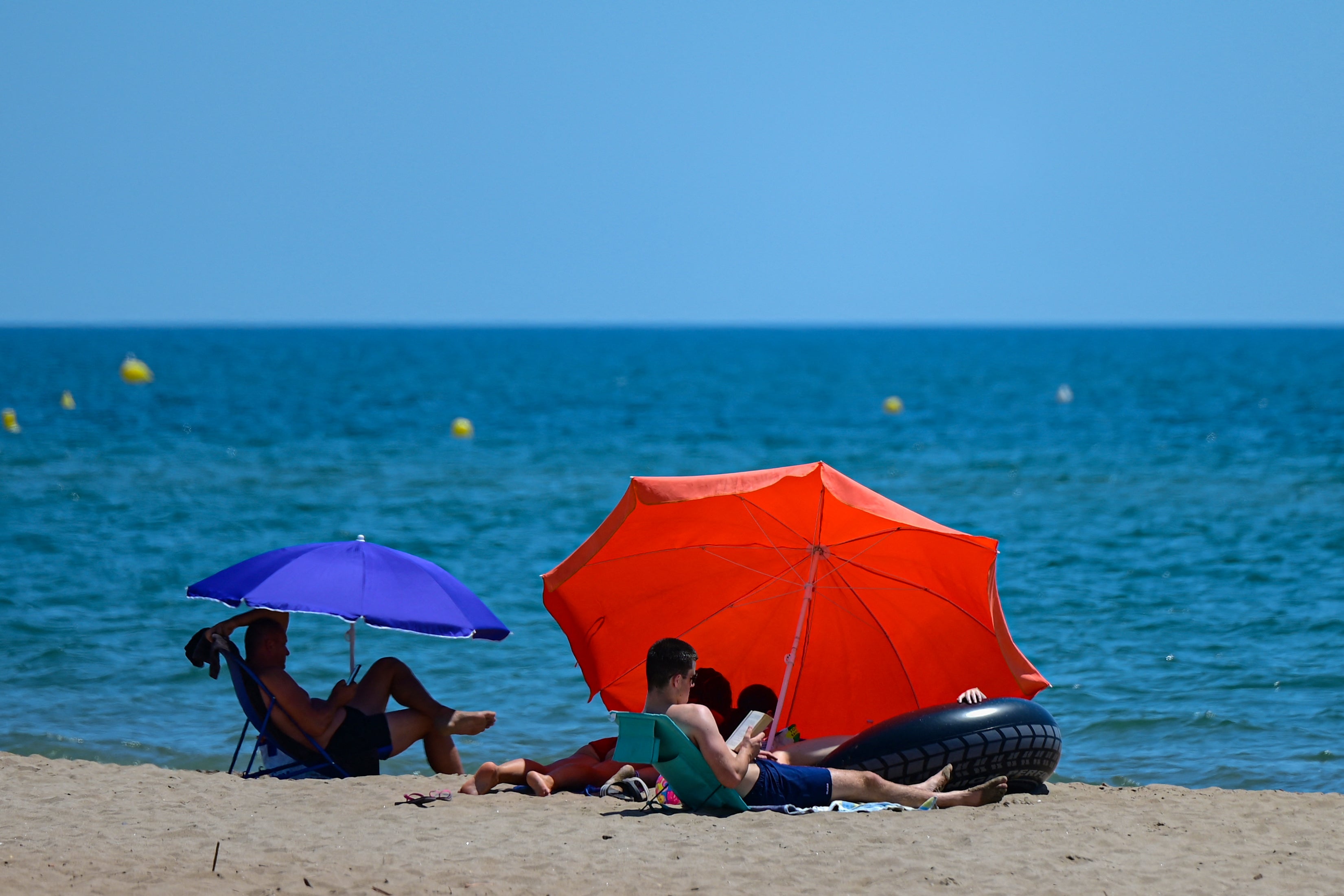 Beachgoers in Portiragnes-Plage near Marseille on Tuesday as temperatures on land soared close to 40C