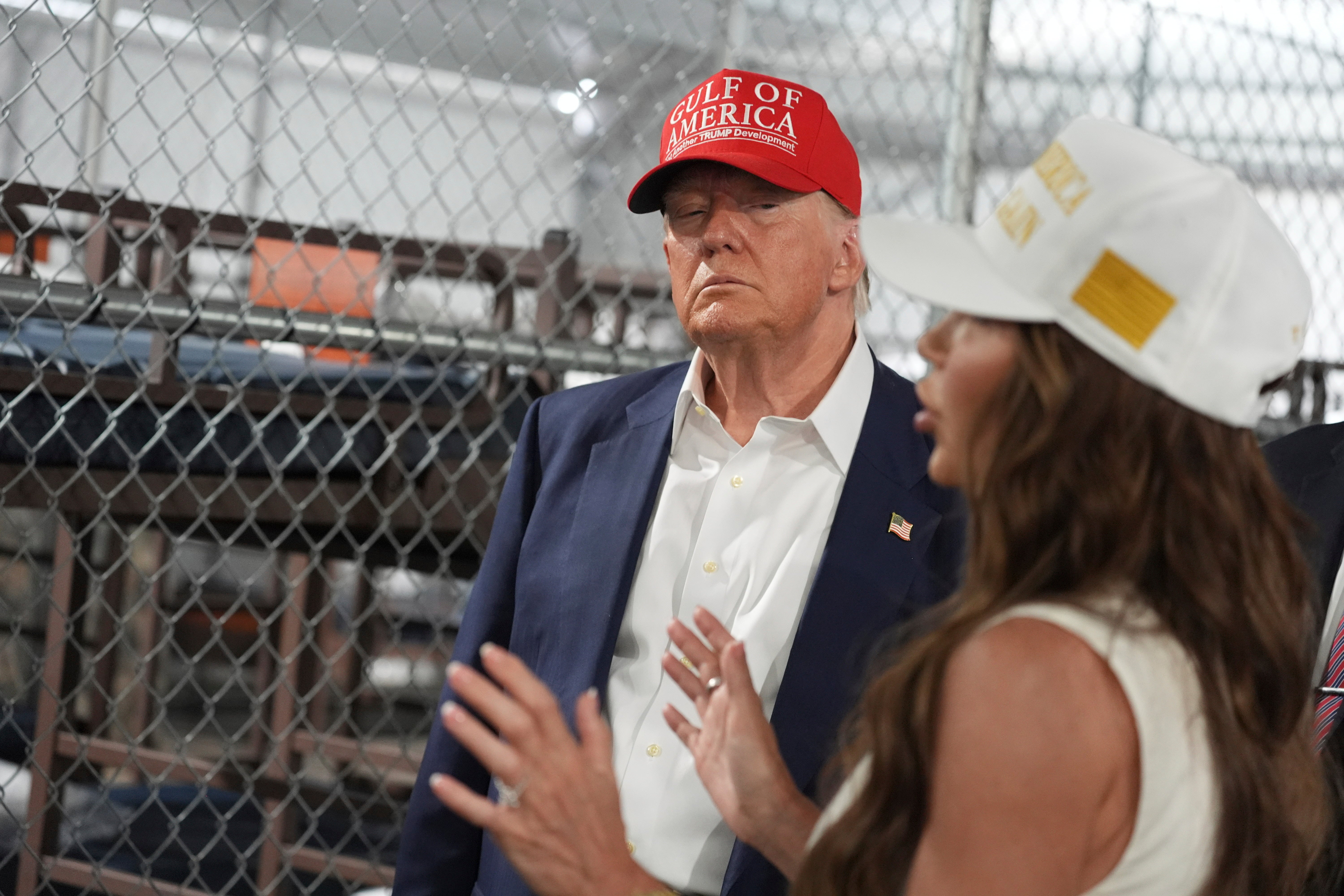 President Donald Trump listens to Homeland Security Secretary Kristi Noem, as they and others tour a new migrant detention facility at Dade-Collier Training and Transition facility, Tuesday, July 1, 2025, in Ochopee, Fla. (AP Photo/Evan Vucci)