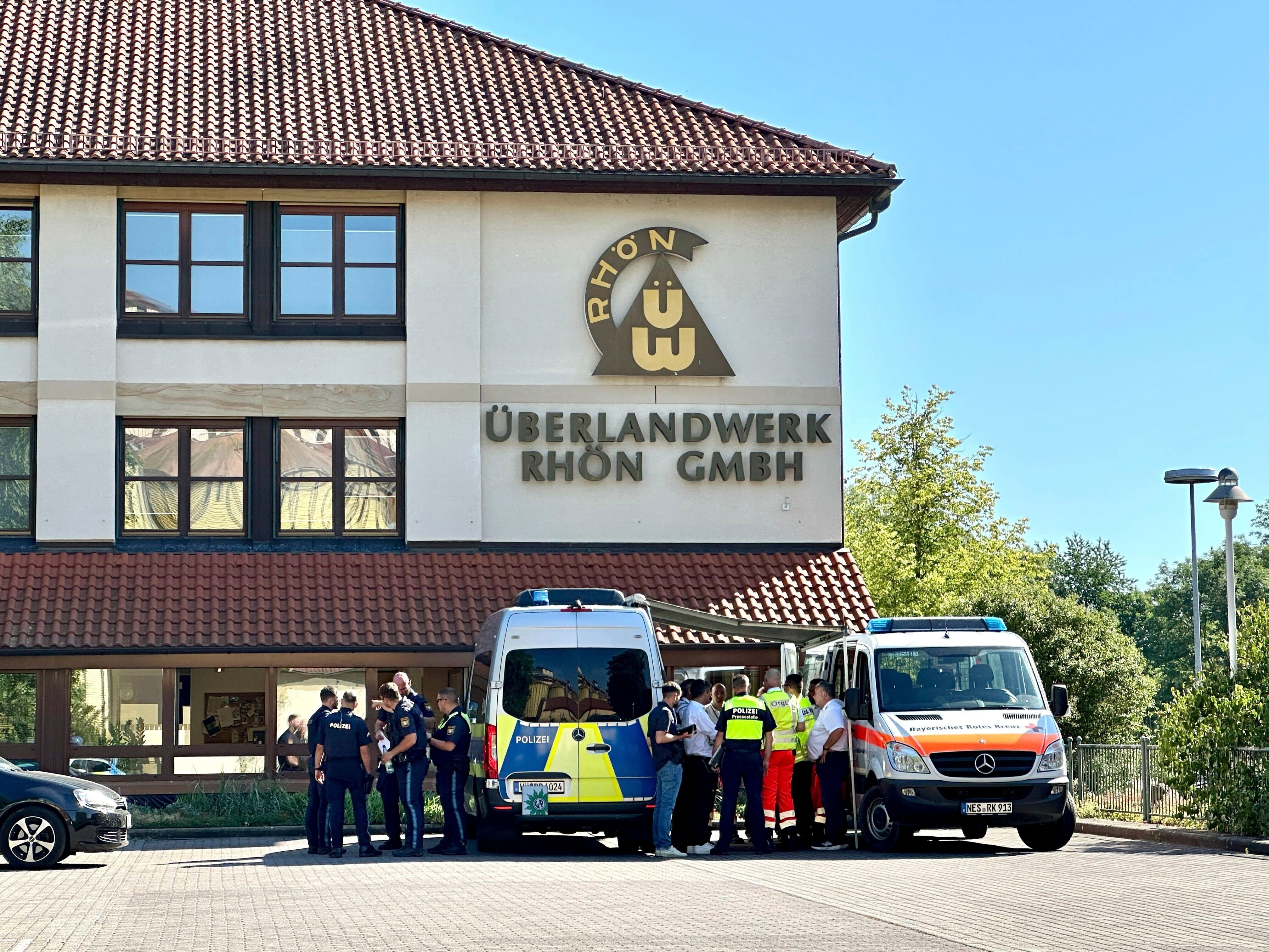 <p>German police and emergency services stand on the premises of a regional grid operator following the stabbing attack</p>