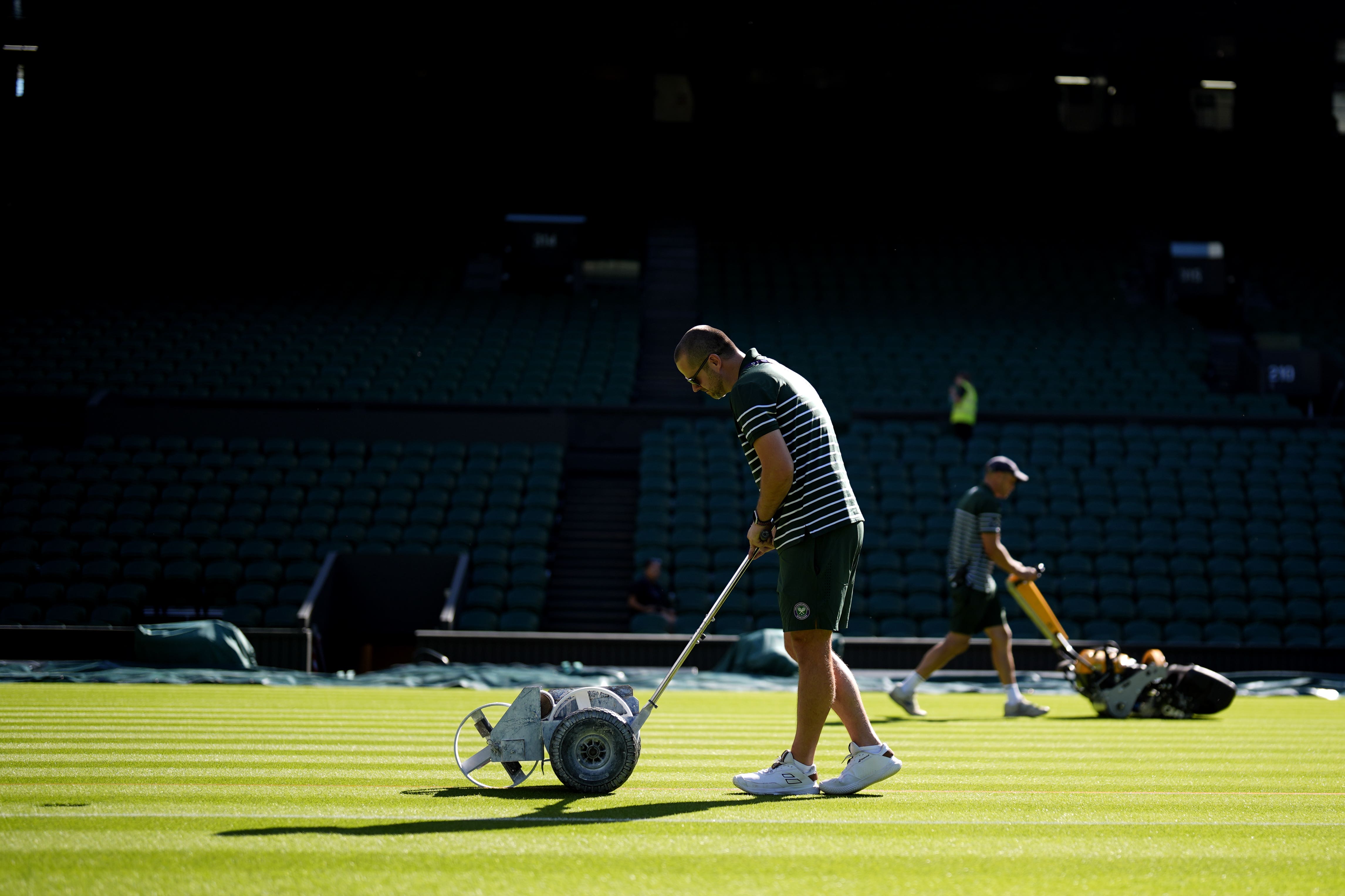 Ground staff preparing centre court on the first day of the 2025 Wimbledon Championships (Jordan Pettitt/PA)