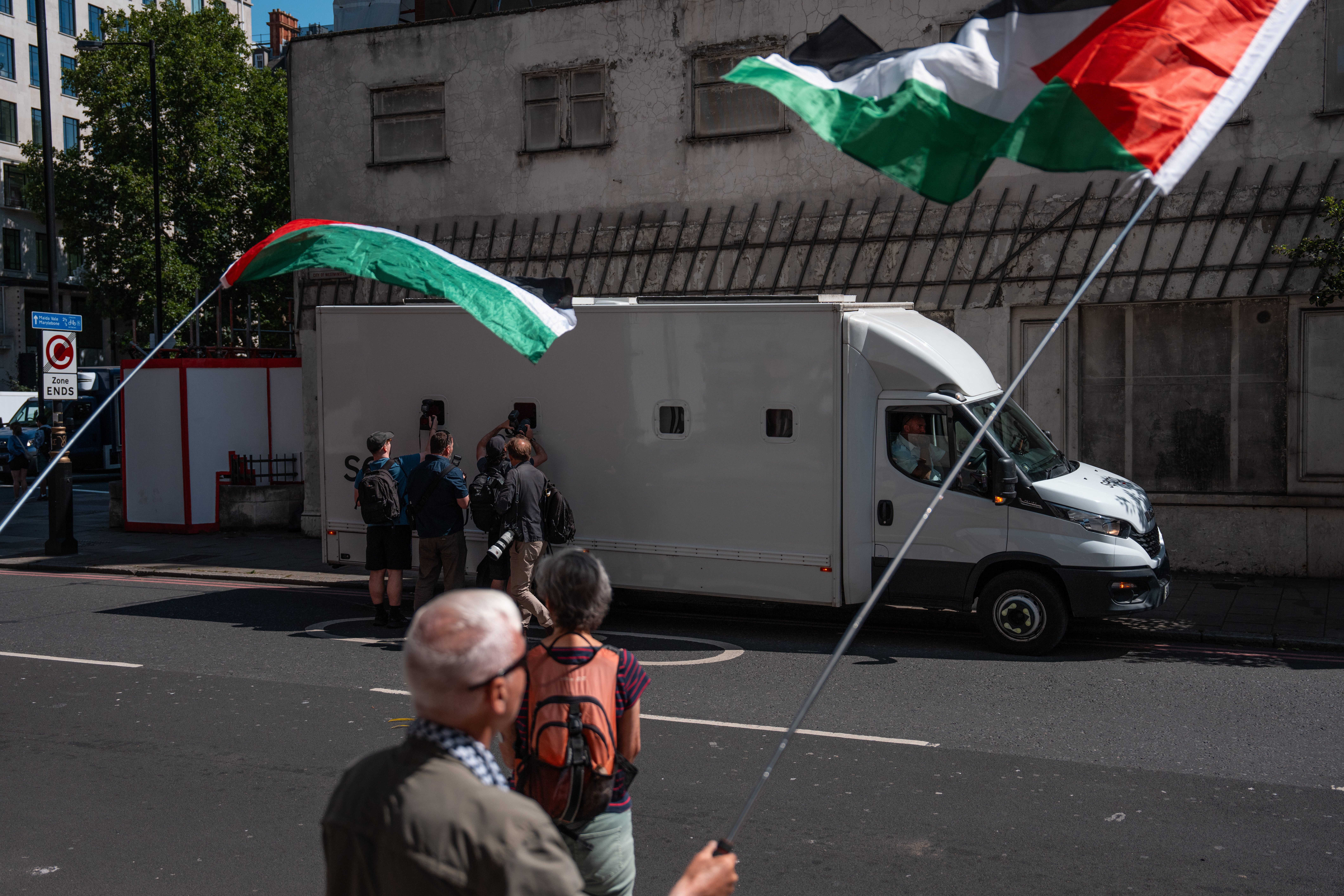 Protesters wave Palestinian flags as a prison van arrives carrying four activists to Westminster Magistrates ‘Court
