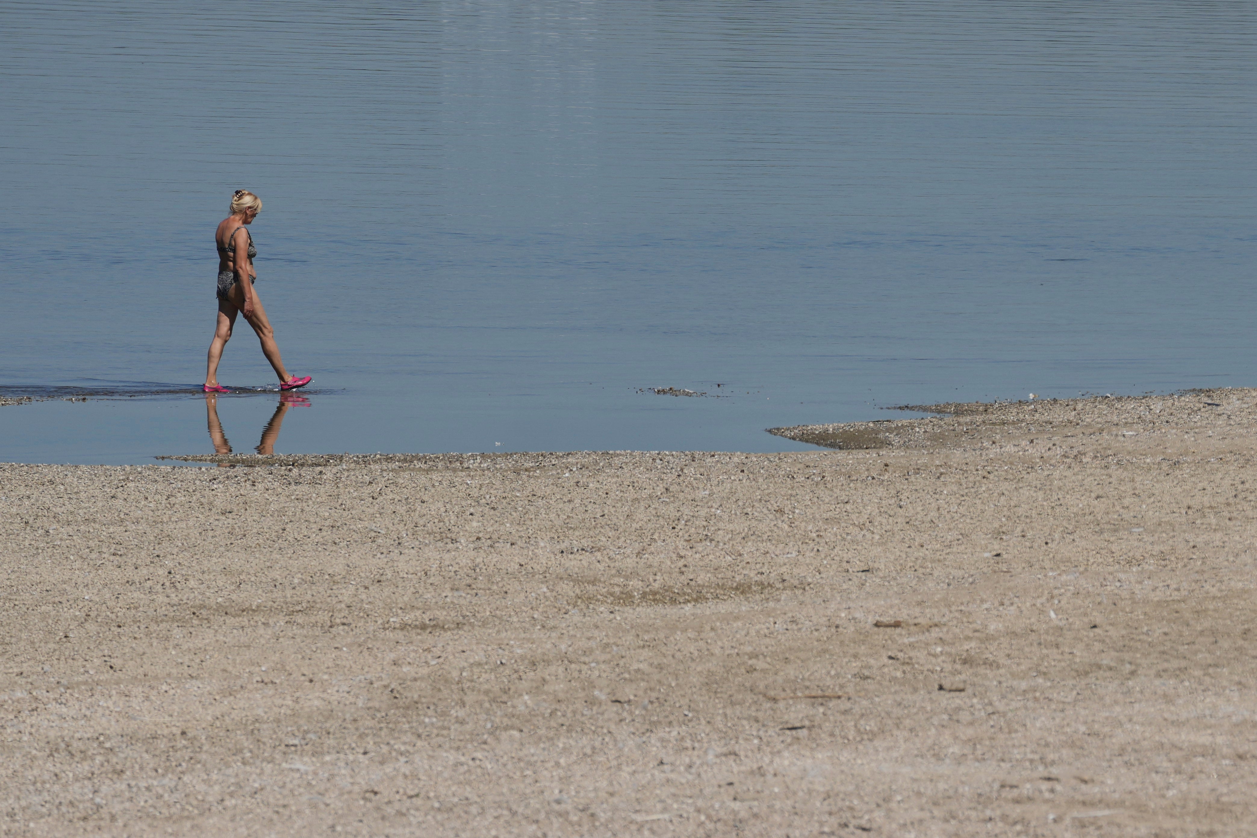 A woman wades through the Danube river during a hot summer day in Belgrade, Serbia