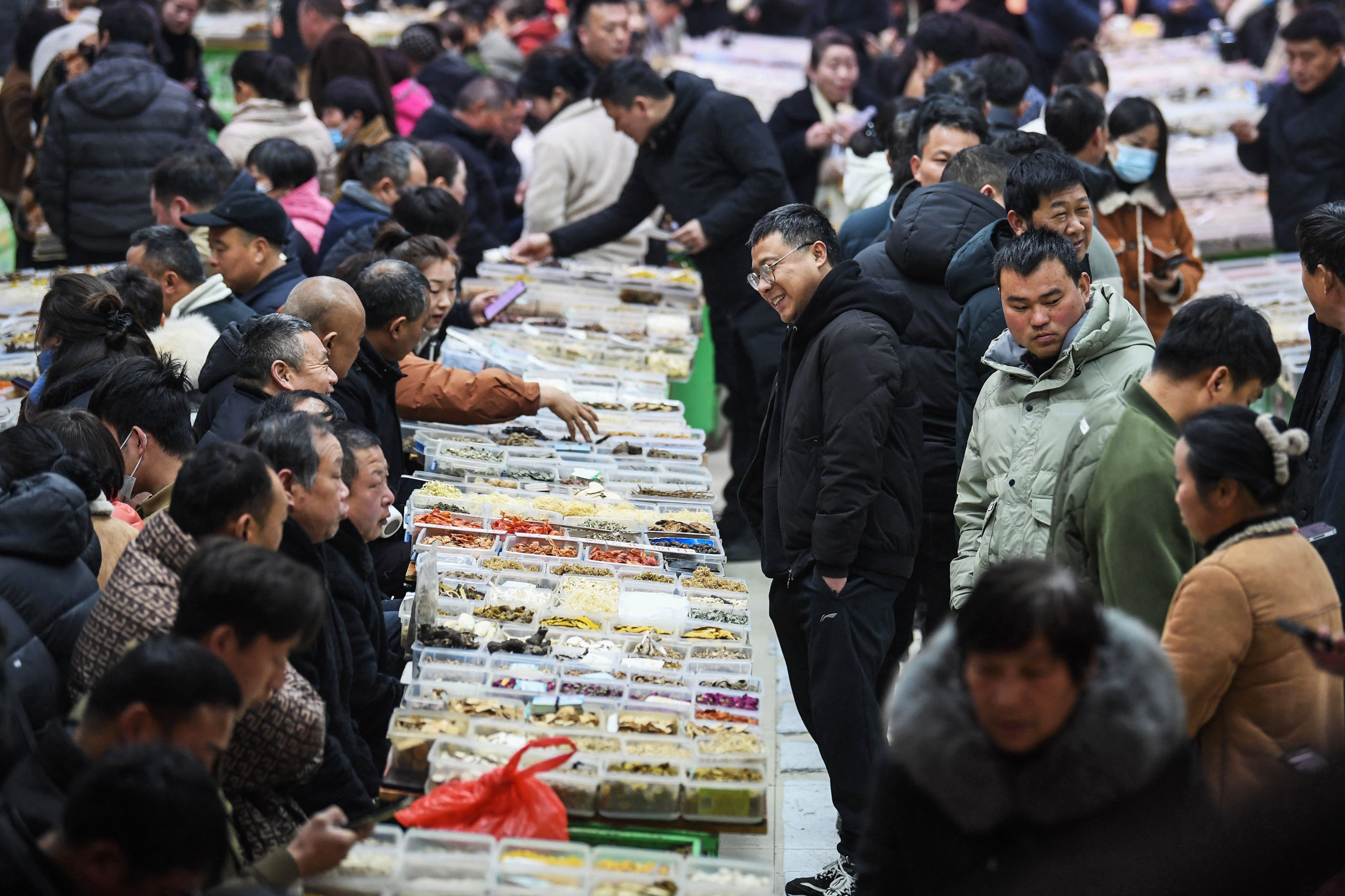 As pessoas estão comprando a medicina tradicional chinesa no mercado de ervas em Bozo, na província de Anhawi, no leste da China