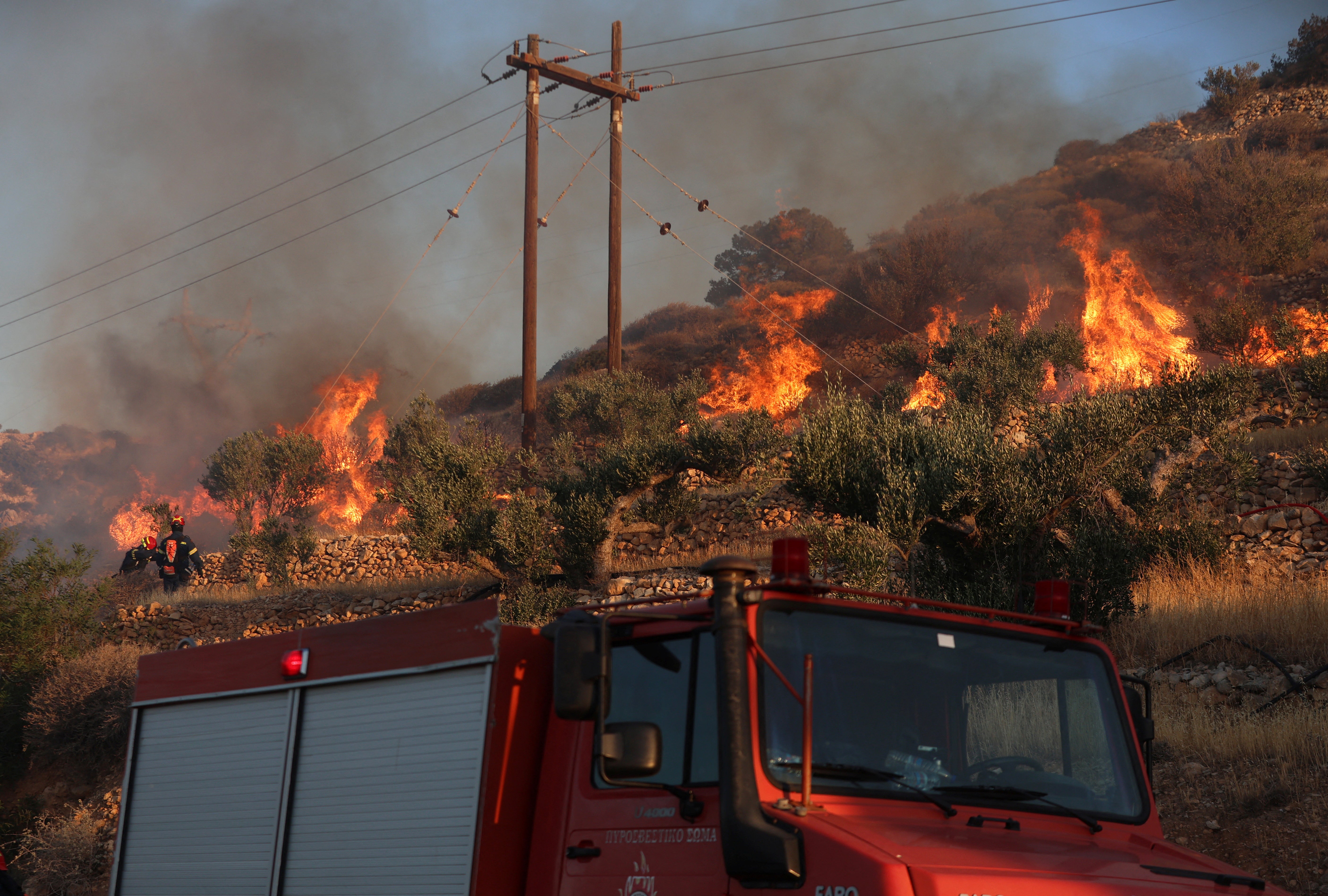 Firefighters try to extinguish a wildfire near Ierapetra, on the island of Crete