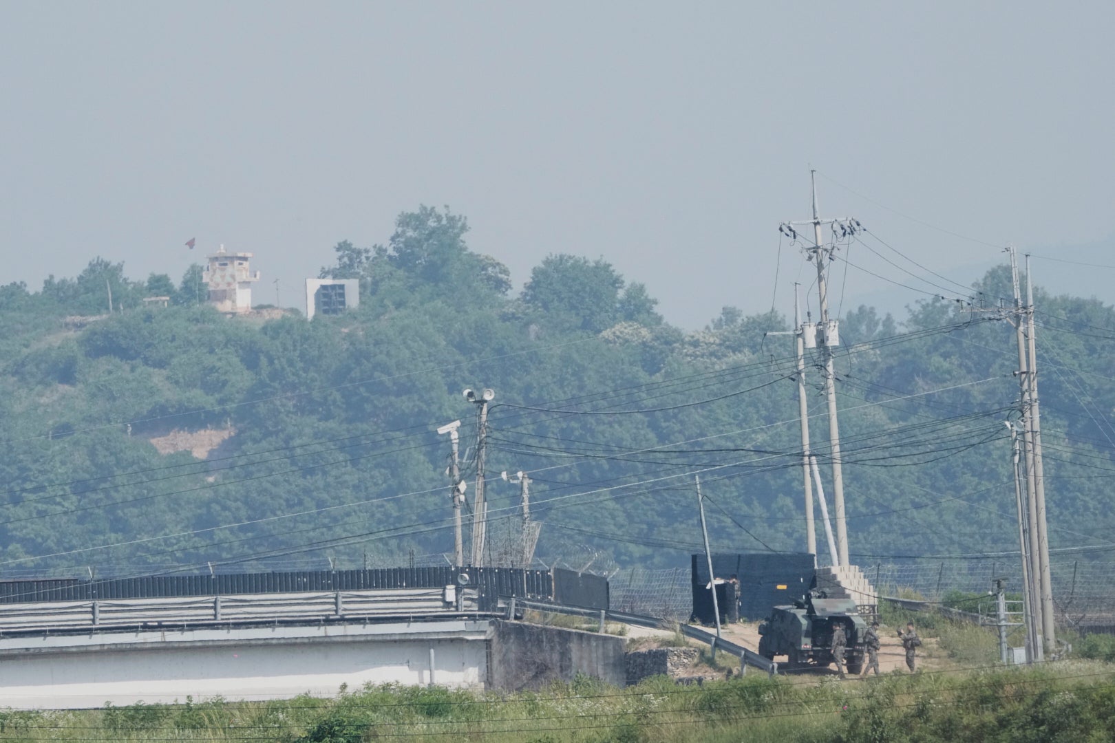 A North Korean military guard post, loudspeaker, top left, and South Korean army soldiers, bottom right, are seen from Paju, South Korea, near the border with North Korea, on June 12, 2025. (AP Photo/Ahn Young-joon)