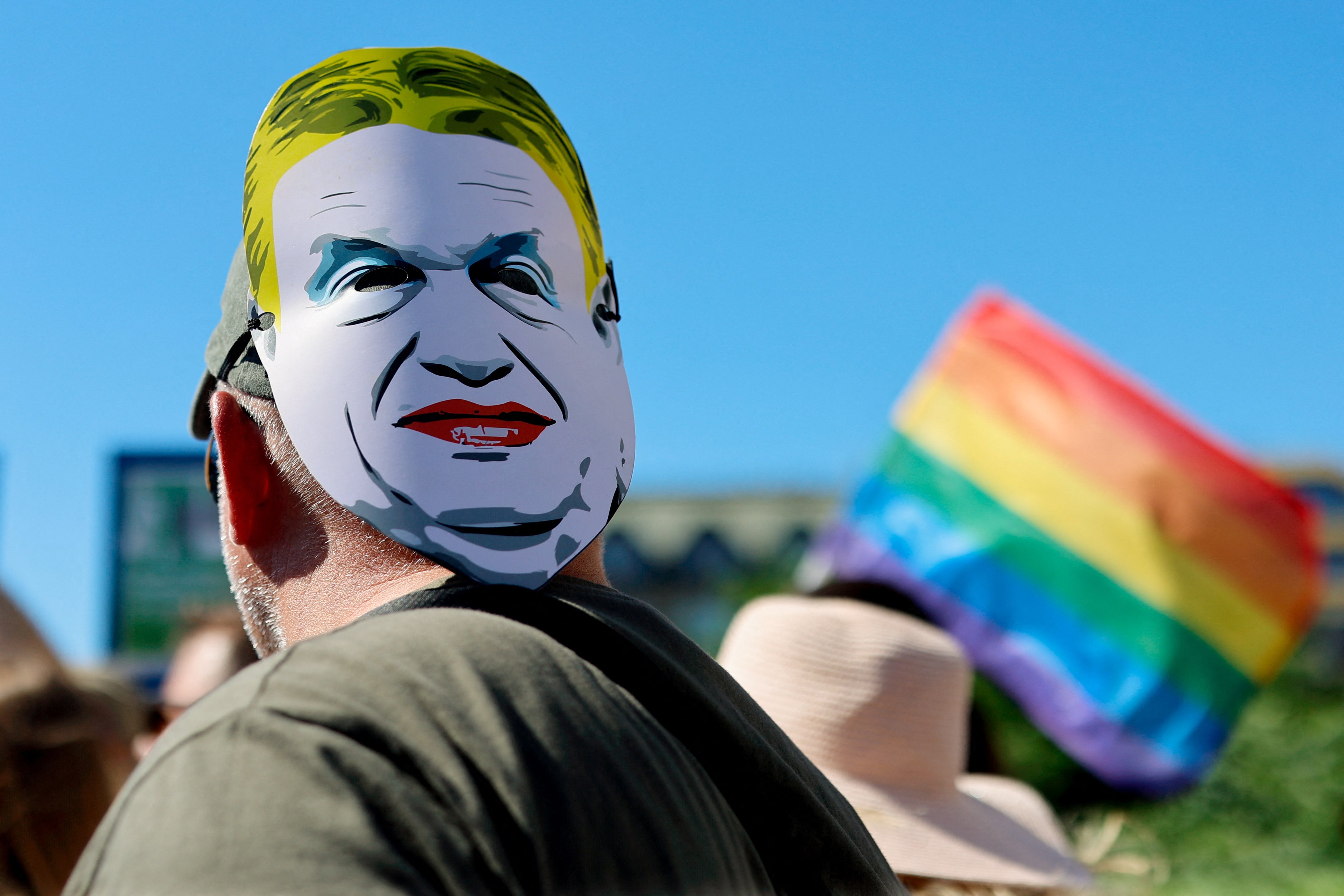 A person wears a mask depicting Hungarian Prime Minister Viktor Orban on the back of the head during the Budapest Pride March