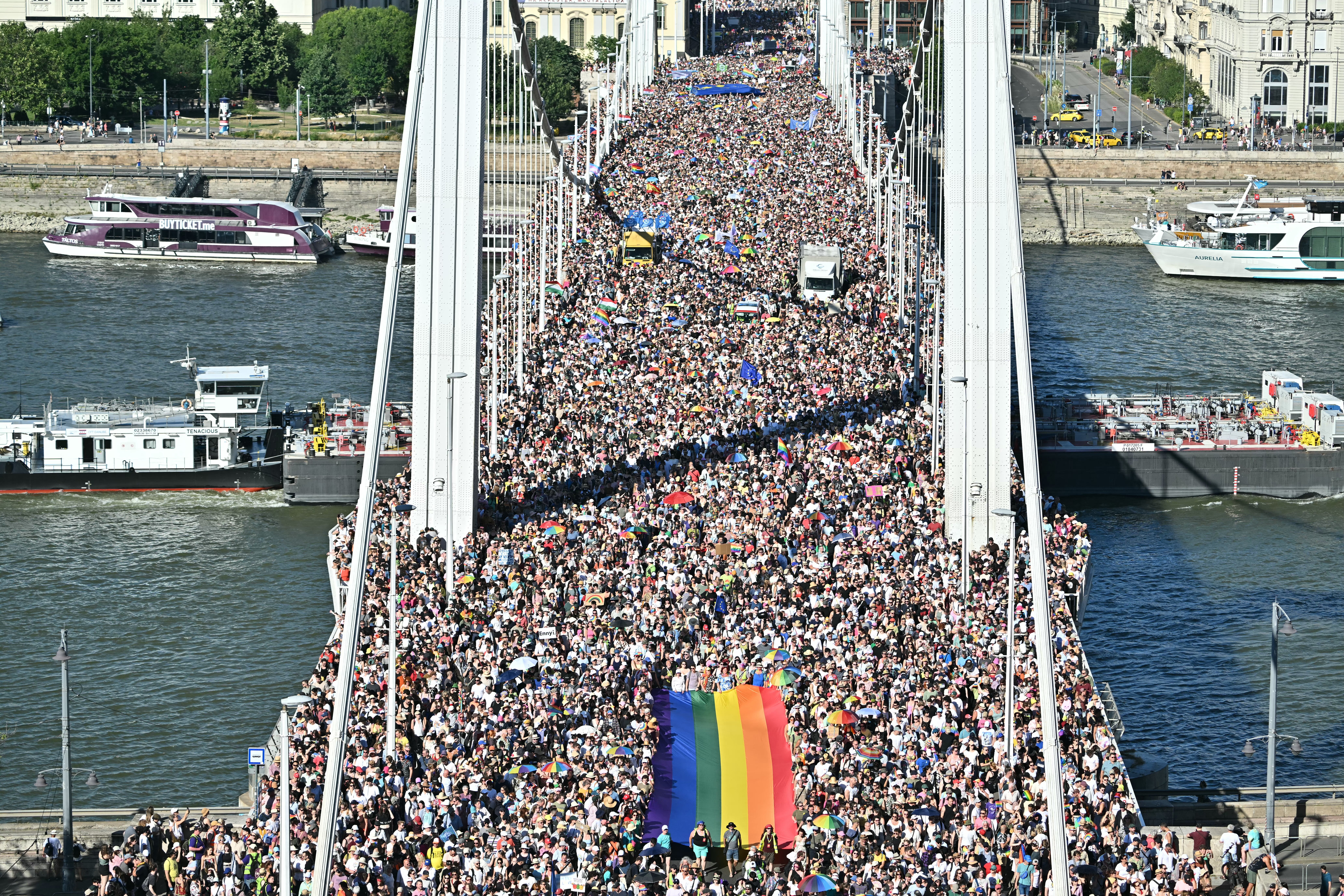 People carry a Rainbow flag as they take part in the Budapest Pride parade in Budapest downtown