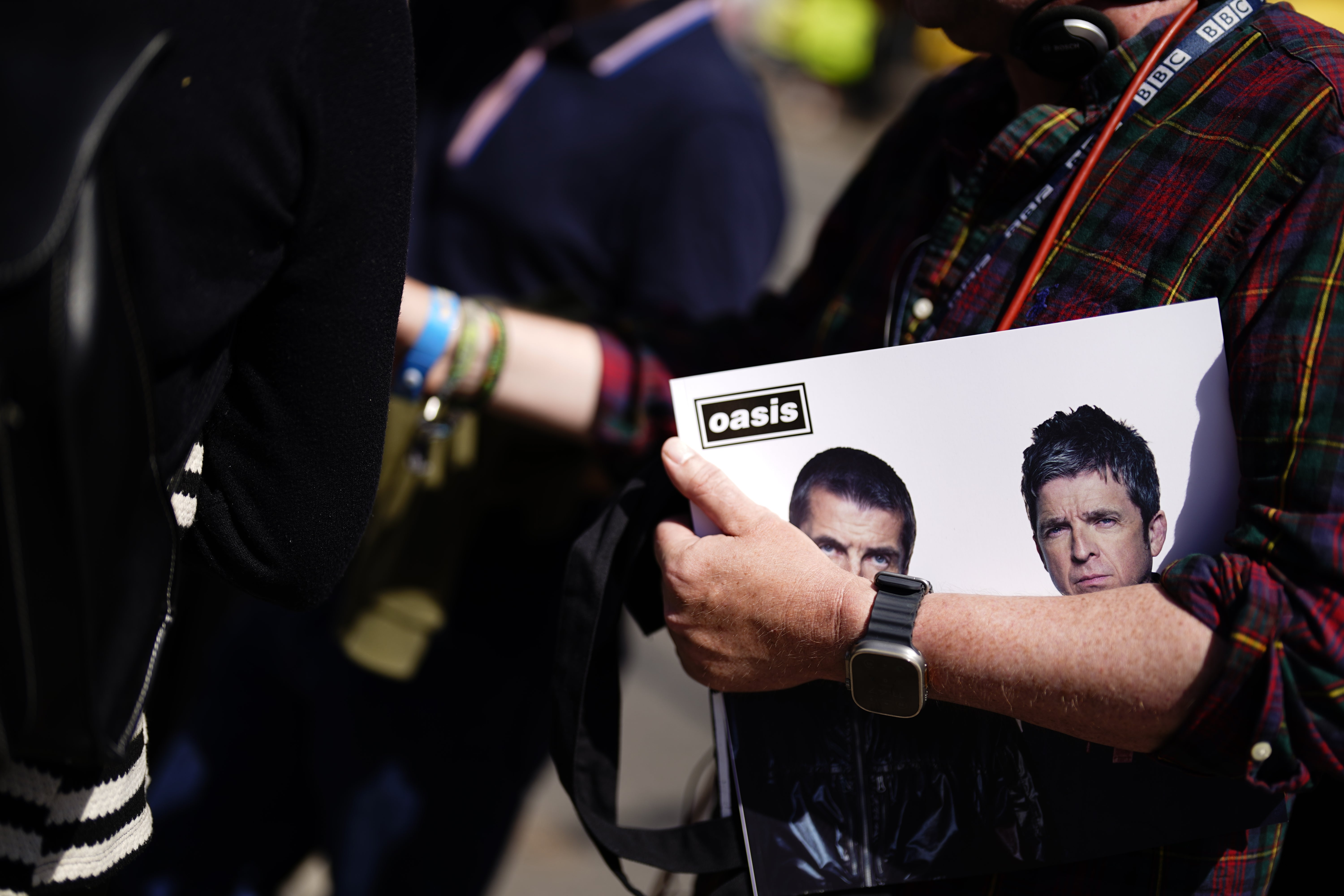 An Oasis fan holds a copy of the souvenir tour programme (Jordan Pettitt/PA)