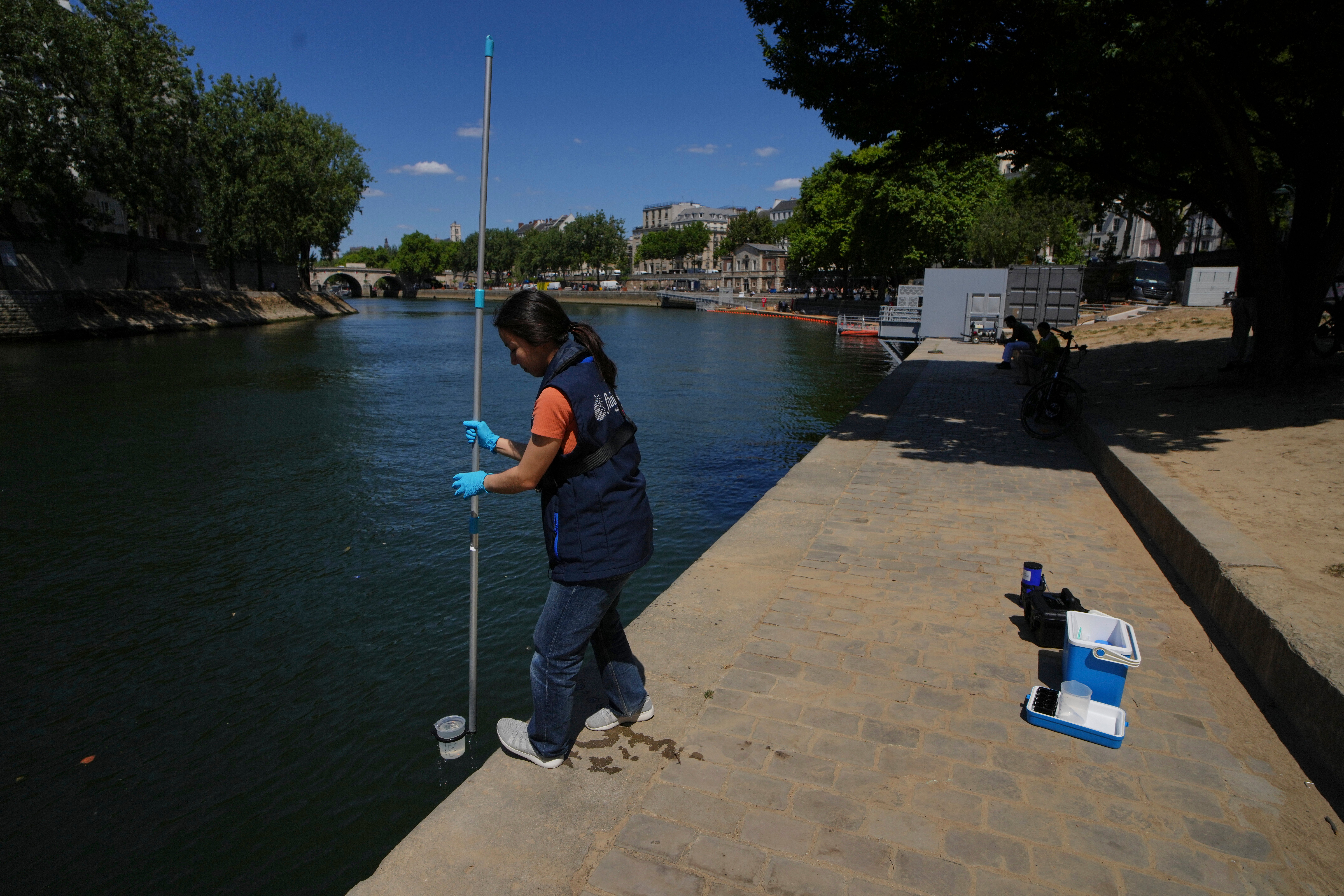 Emilie Vilana of Fluidion takes a sample from the Seine river to test the water quality
