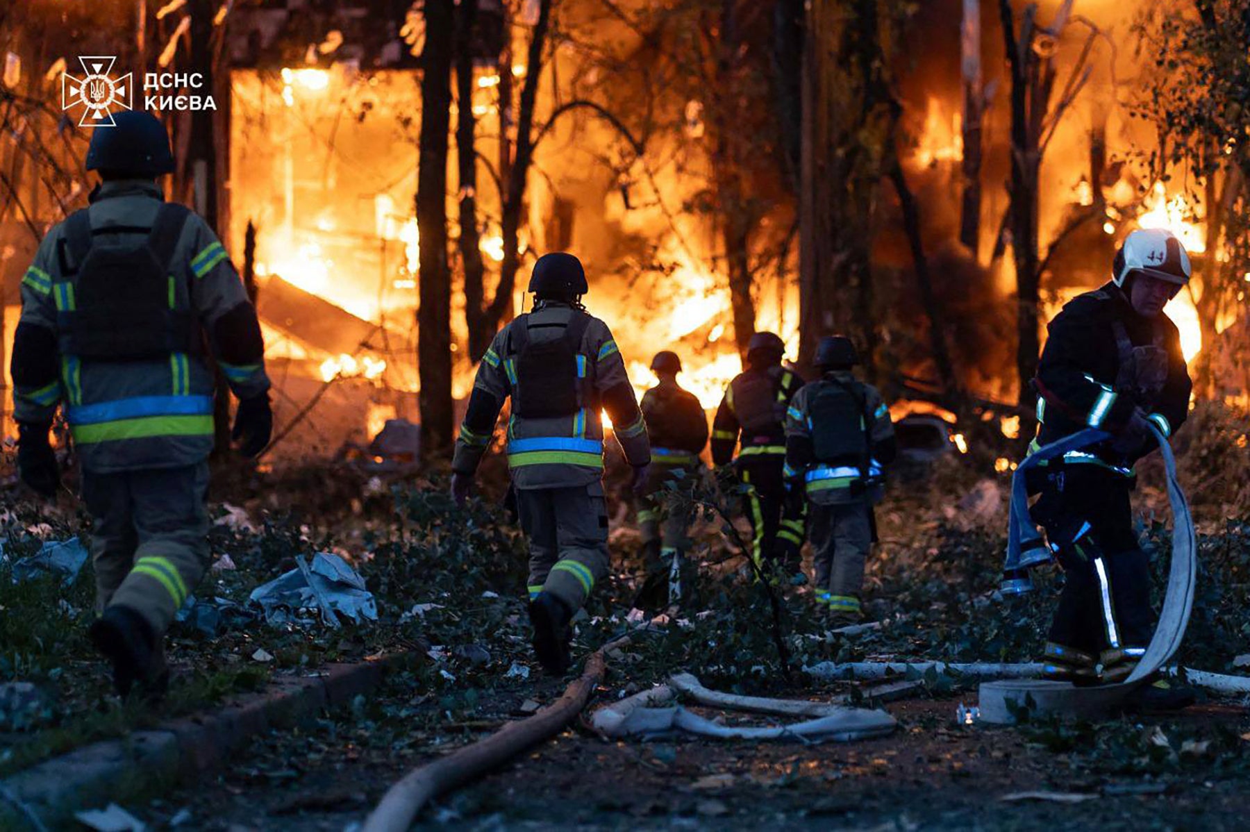 Firefighters at the site of a strike on Kyiv by Russian drones and missiles
