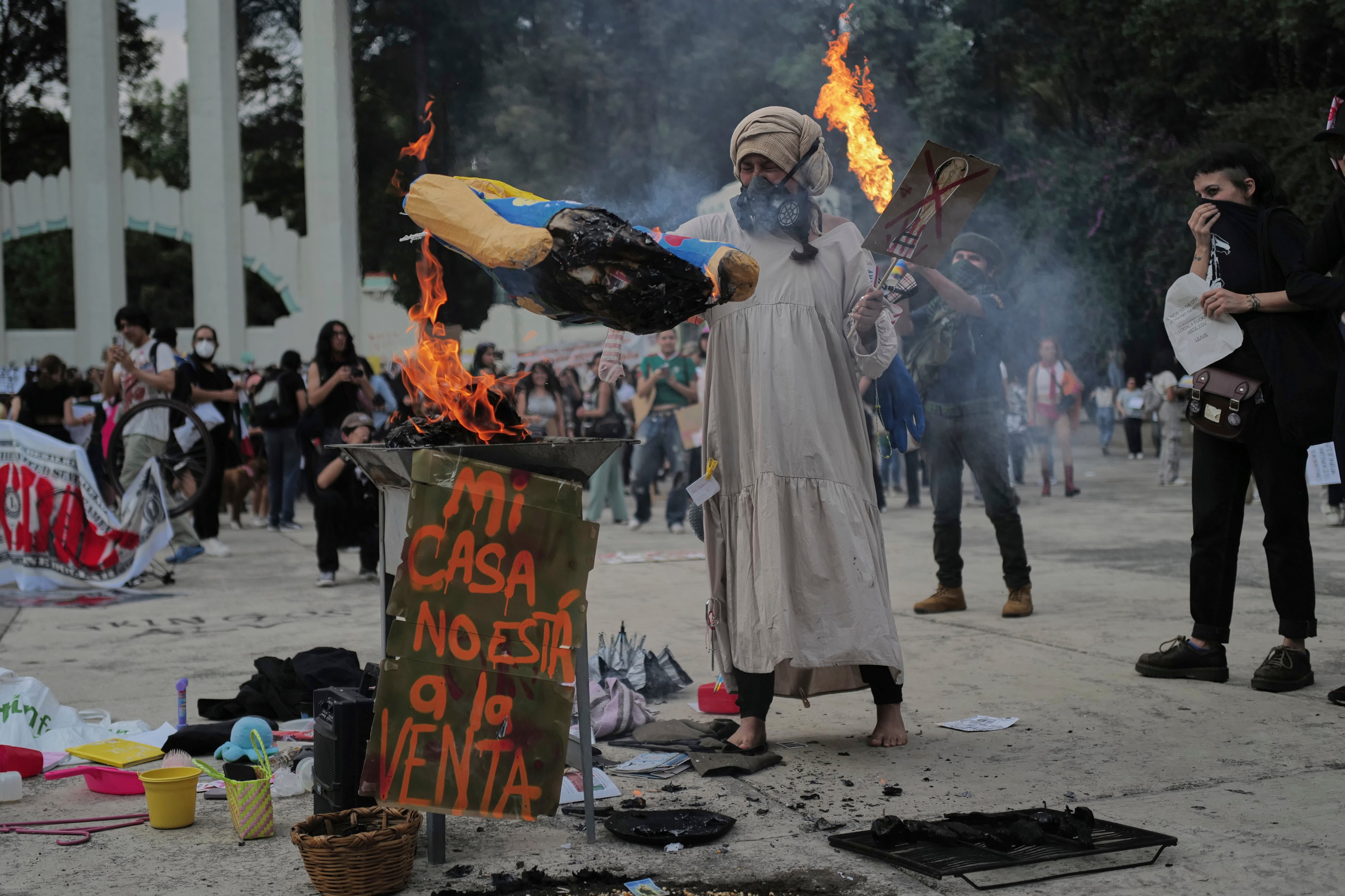 A demonstrator burns an effigy of U.S. President Donald Trump in Parque Mexico, during a protest against gentrification