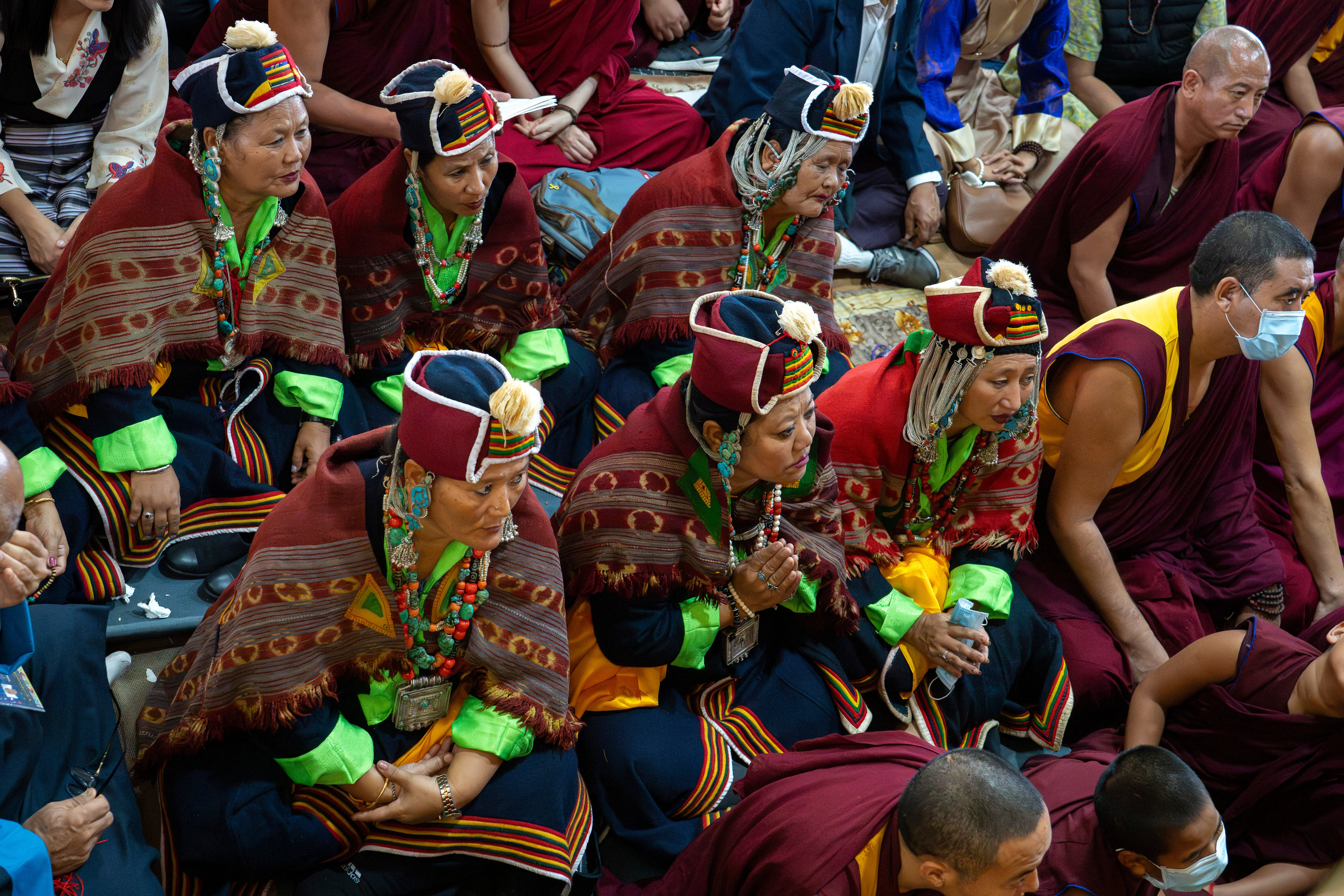 Devotees watch Tibetan spiritual leader the Dalai Lama on a television screen at an event during which Tibetan exiles prayed for the Tibetan leader's longevity