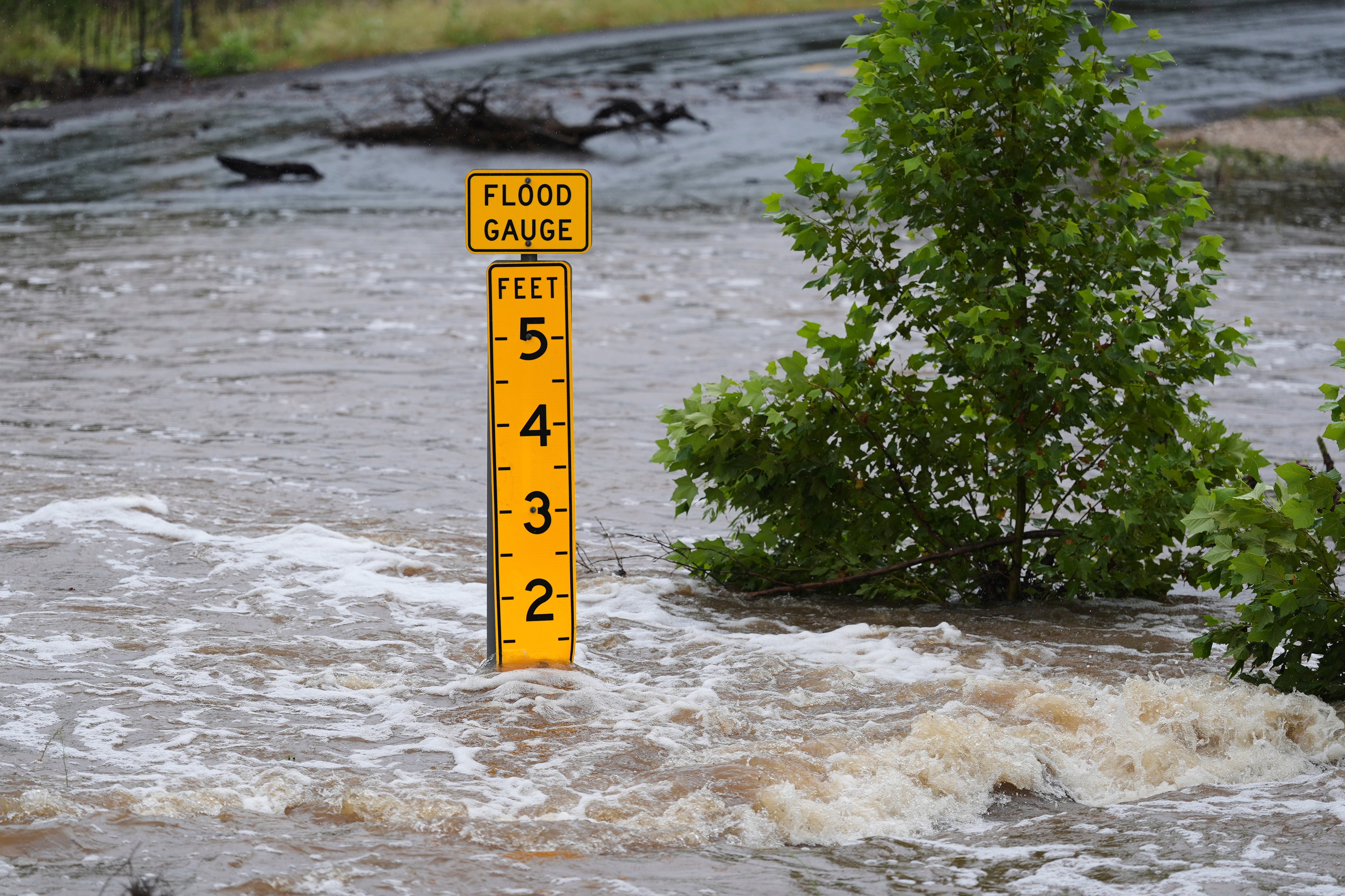 A flood gauge marks the height of water flowing over a farm-to-market road near Kerrville, Texas, on July 4.