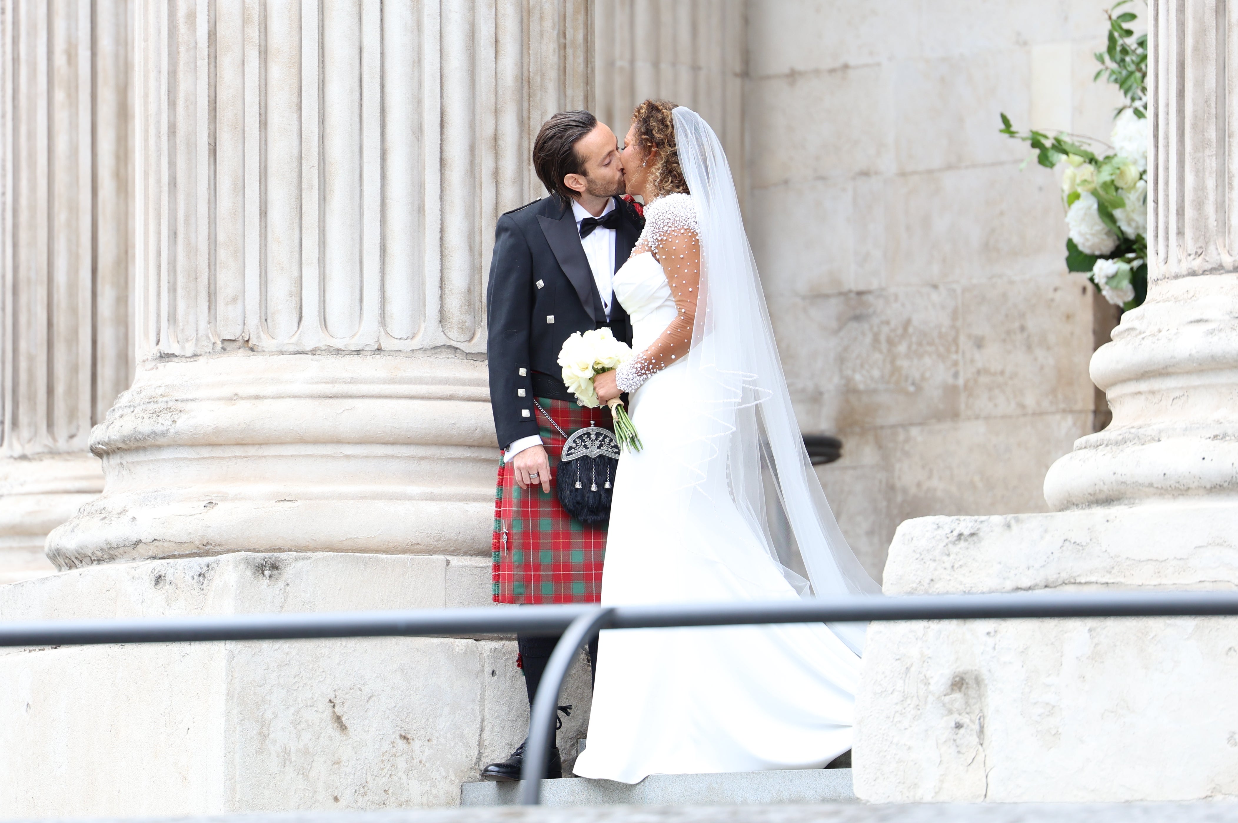 Melanie Brown and Rory McPhee kiss at St Paul’s Cathedral, London, after their wedding (Toby Shepheard/PA)