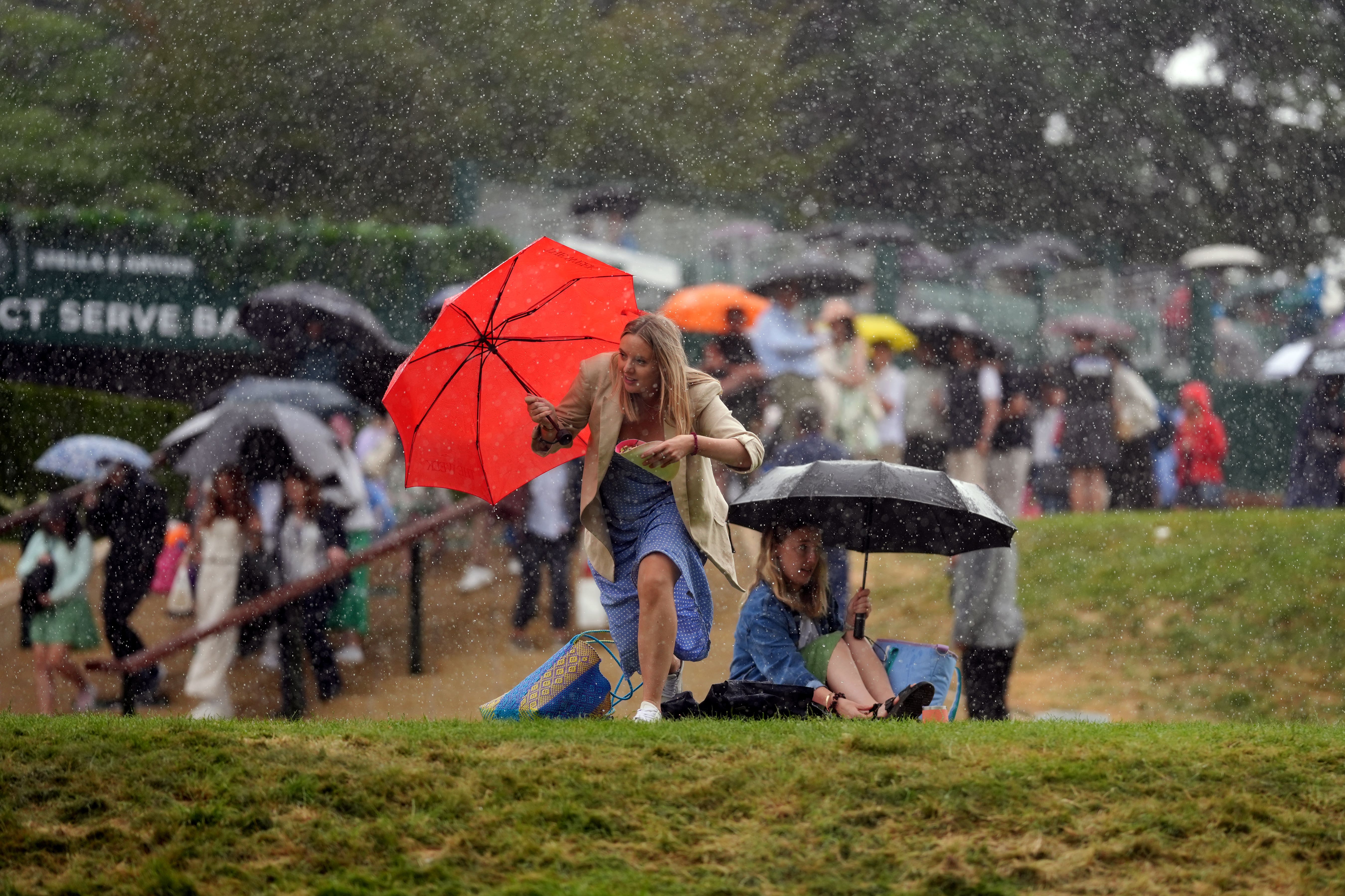 Spectators flea from the hill amid a heavy downpour (John Walton/PA)