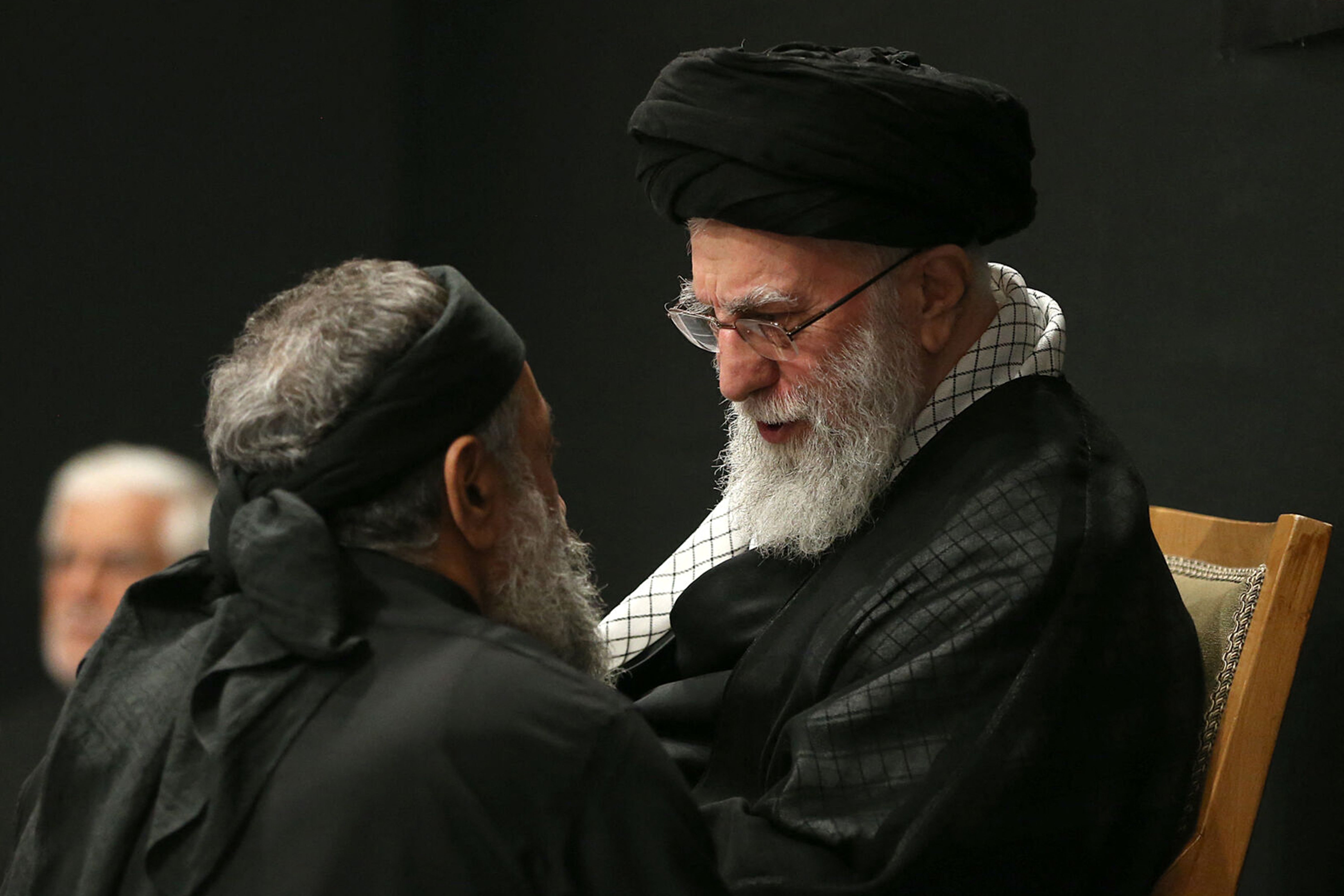 Khamenei speaking with a mourner during a mourning ceremony in Tehran marking the ninth day of the Islamic month of Muharram in the lead-up to Ashura