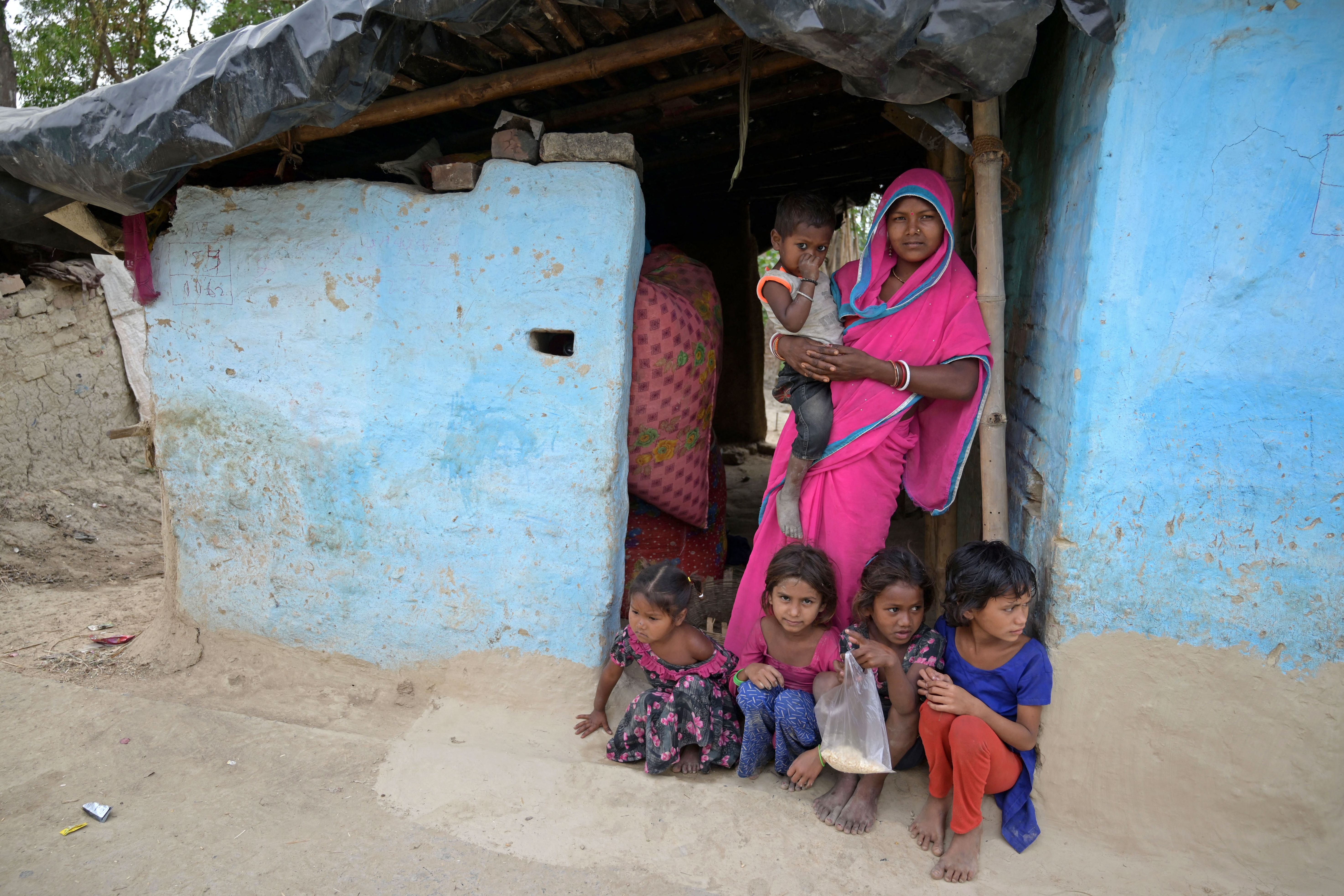 Gita Devi, a mother of five, poses with her children at her village house in the Darbhanga district of India’s Bihar state in 2023