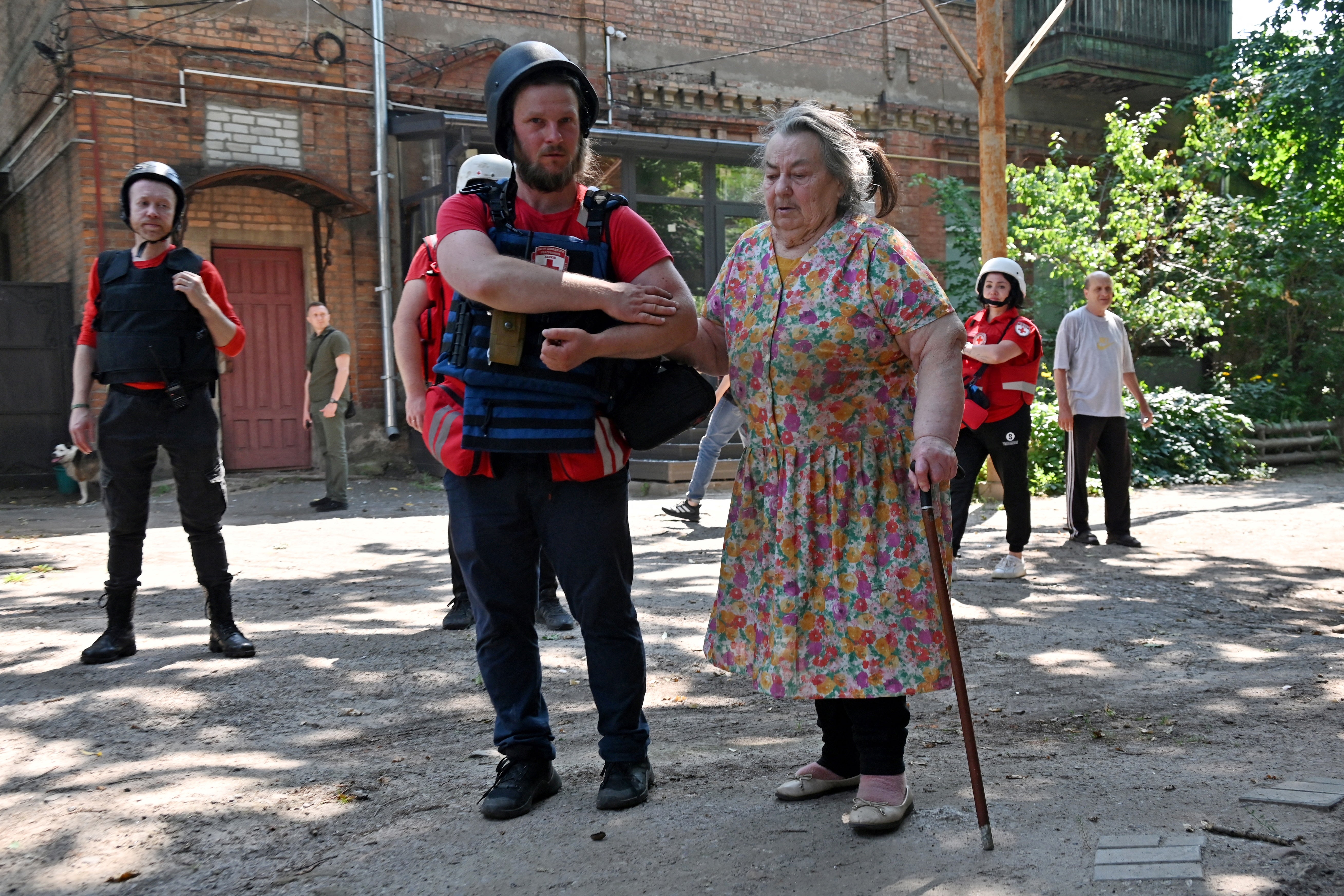 A Ukrainian medic helps a woman leave the site of a drone attack in Kharkiv on Monday amid the Russian invasion of Ukraine