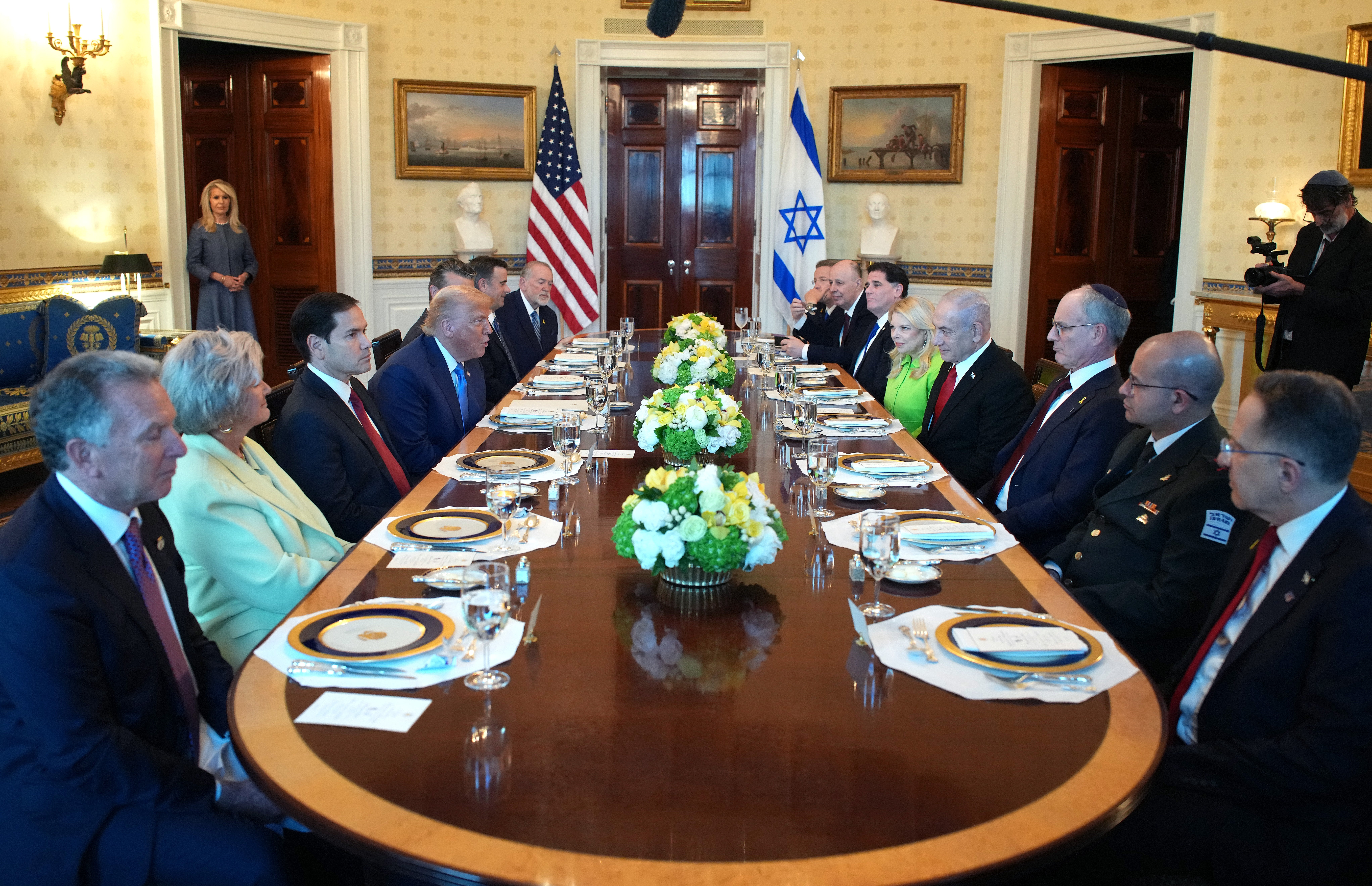 The table was set with 14 place settings and floral centerpieces, and the American and Israeli flags were displayed by the door