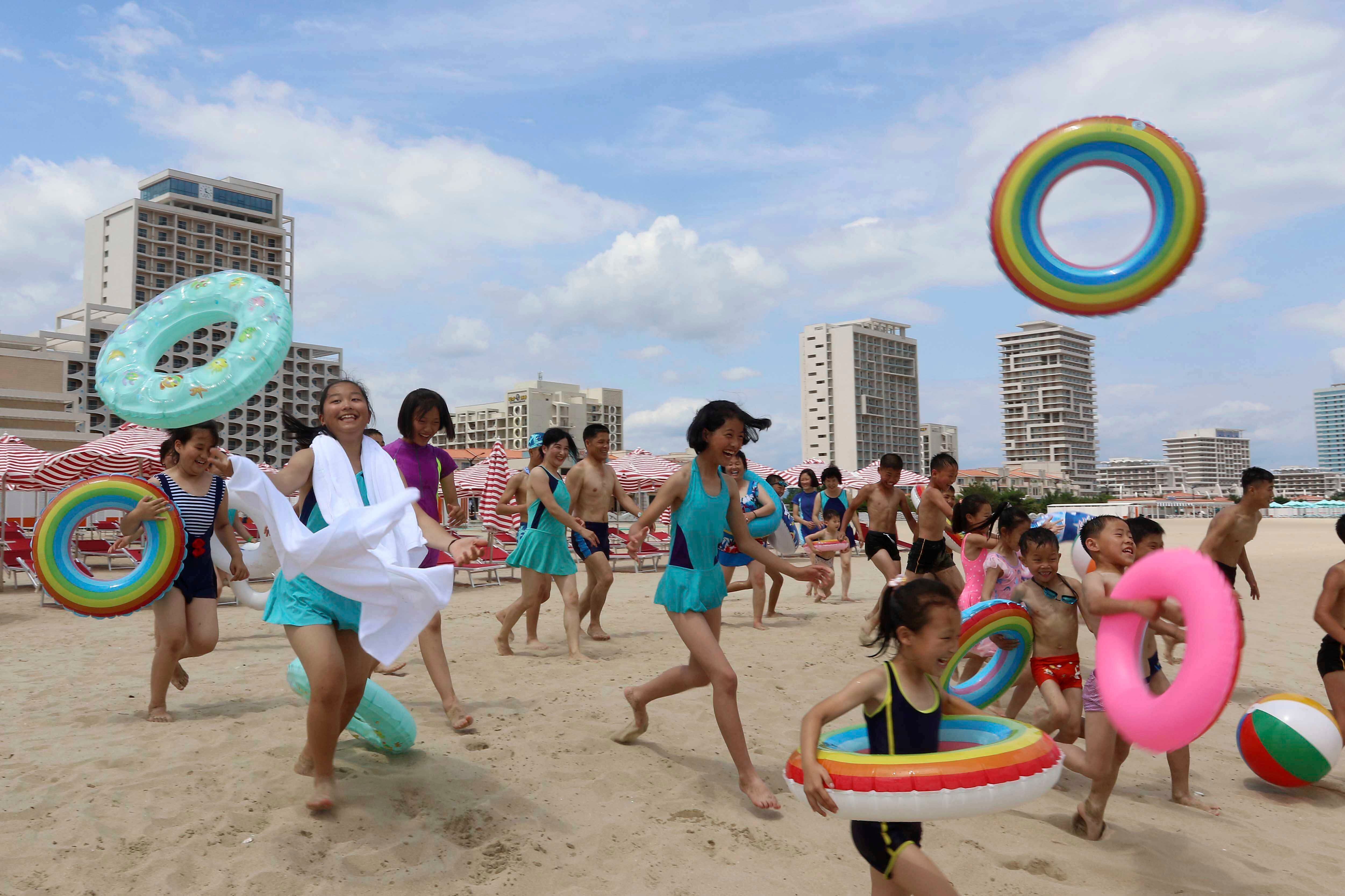 Children run into sea at the Wonsan-Kalma resort on 2 July 2025