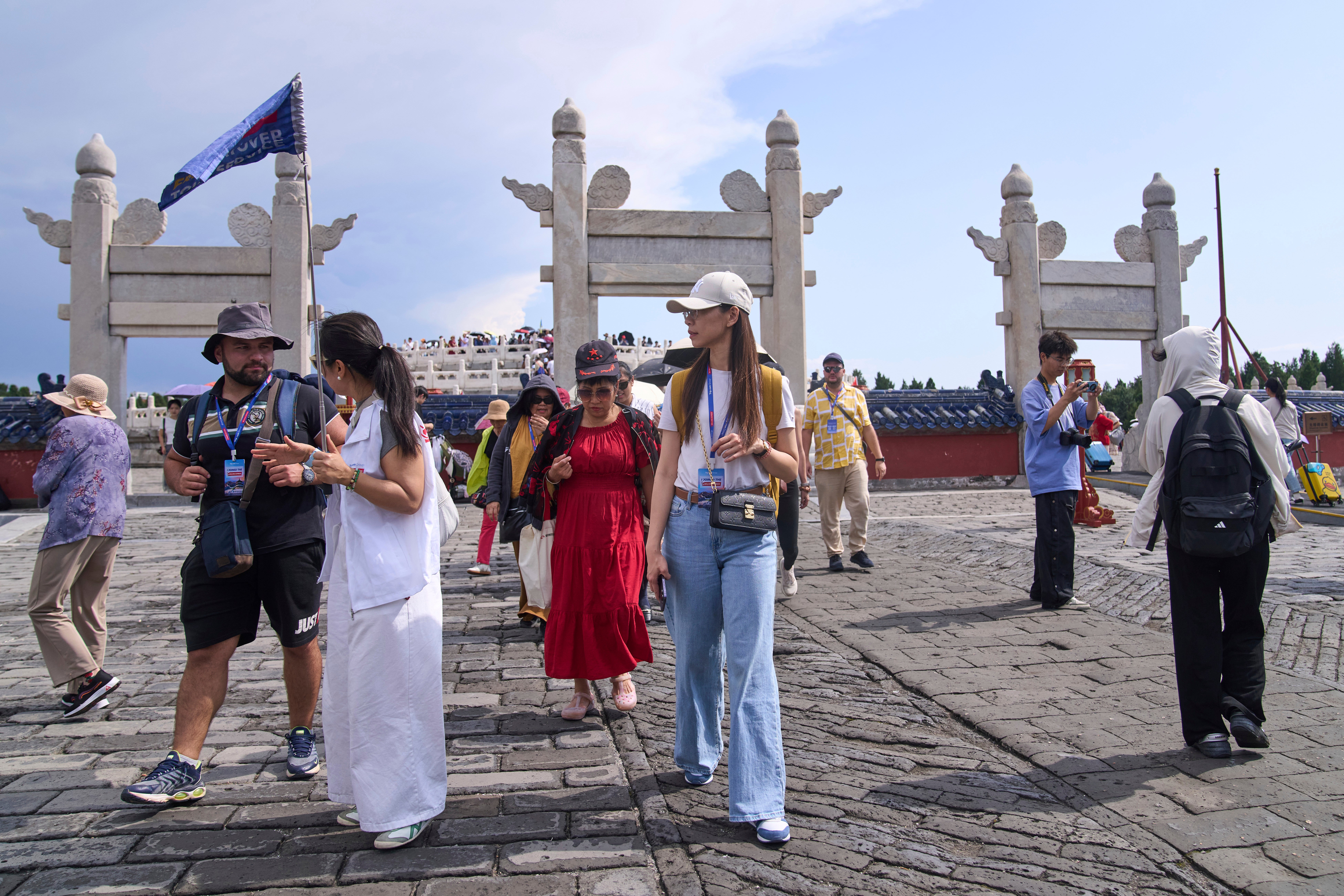 A tour guide chats with tourists at the Temple of Heaven in Beijing
