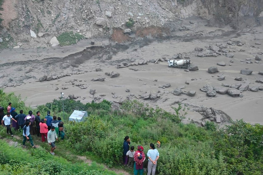 People watch overflowing river amid flooding in Nepal