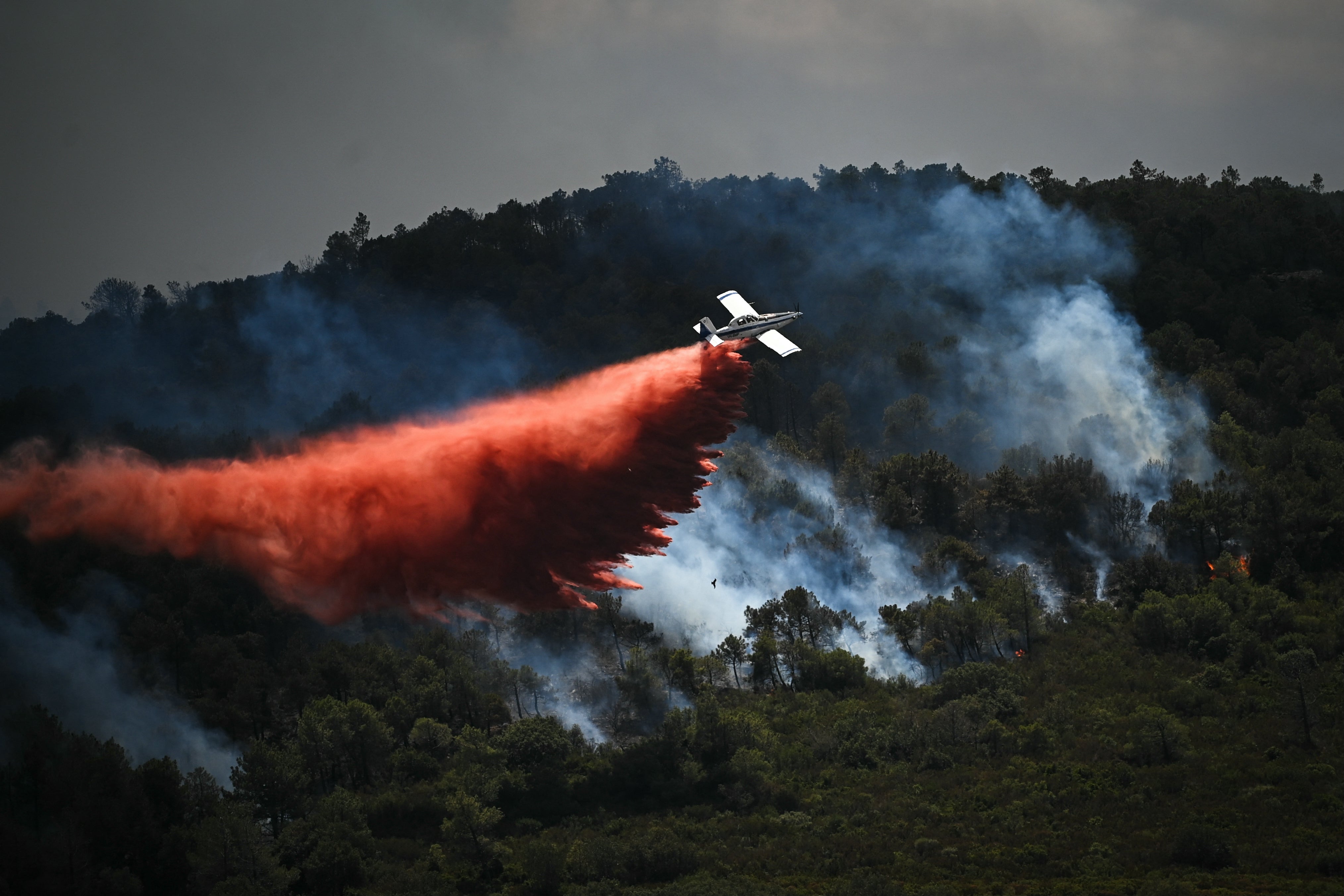 A fire-fighting aircraft at the site of a wildfire close to the city of Narbonne