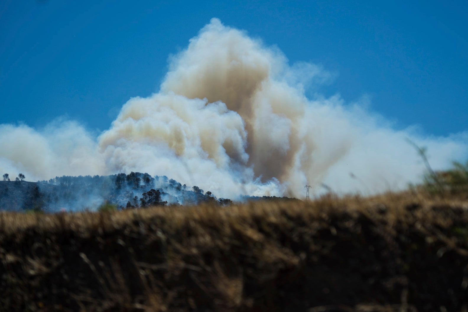 This photo provided by the fire brigade Pompiers13, shows a cloud of smoke over hills near Marseille, southern France, Tuesday, July 8, 2025. (Pompiers13 via AP)