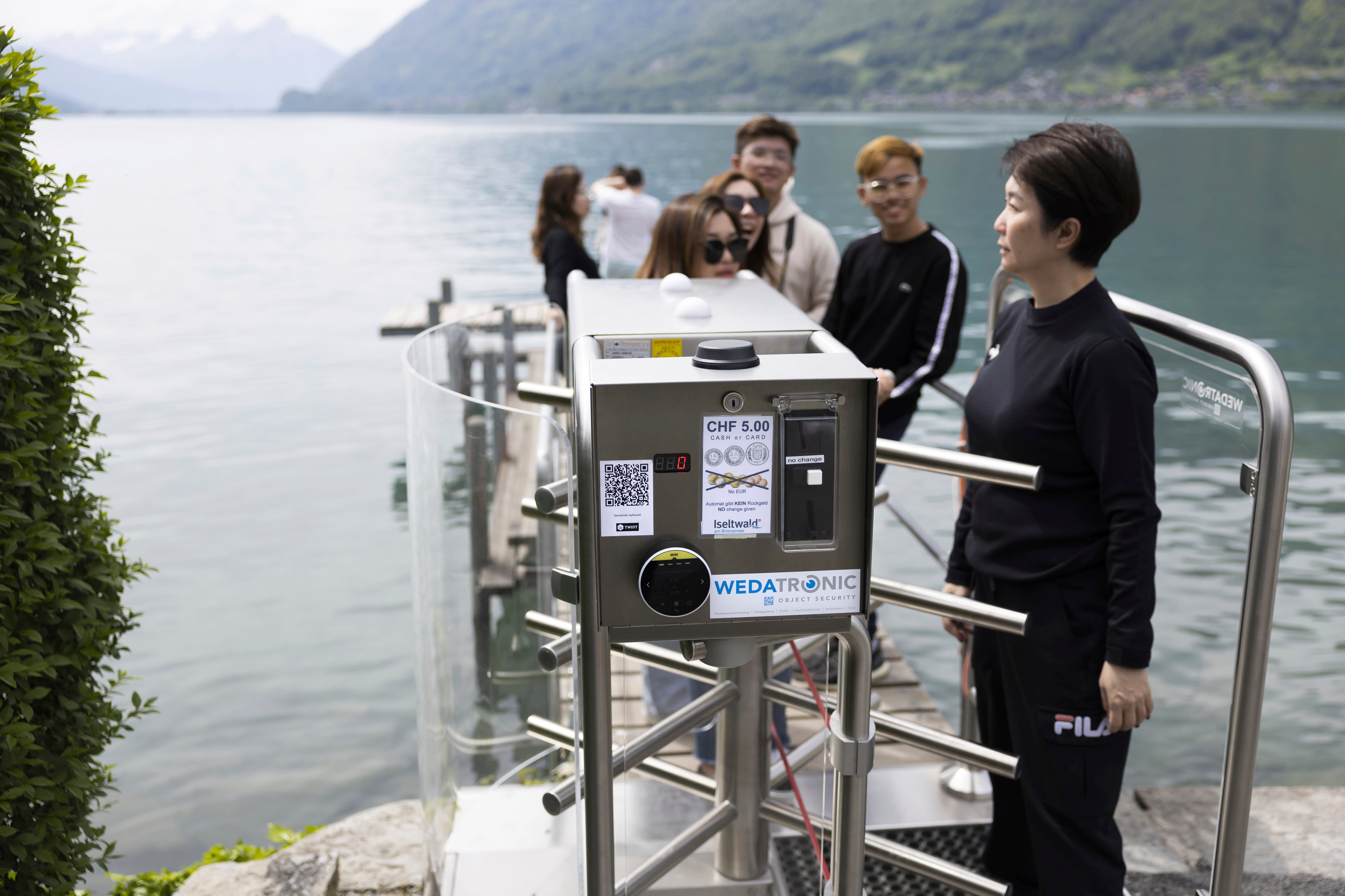 Korean visitors get on the pier at Lake Brienz after paying 5 Swiss Francs in Iseltwald, Switzerland, Sunday, May 21, 2023