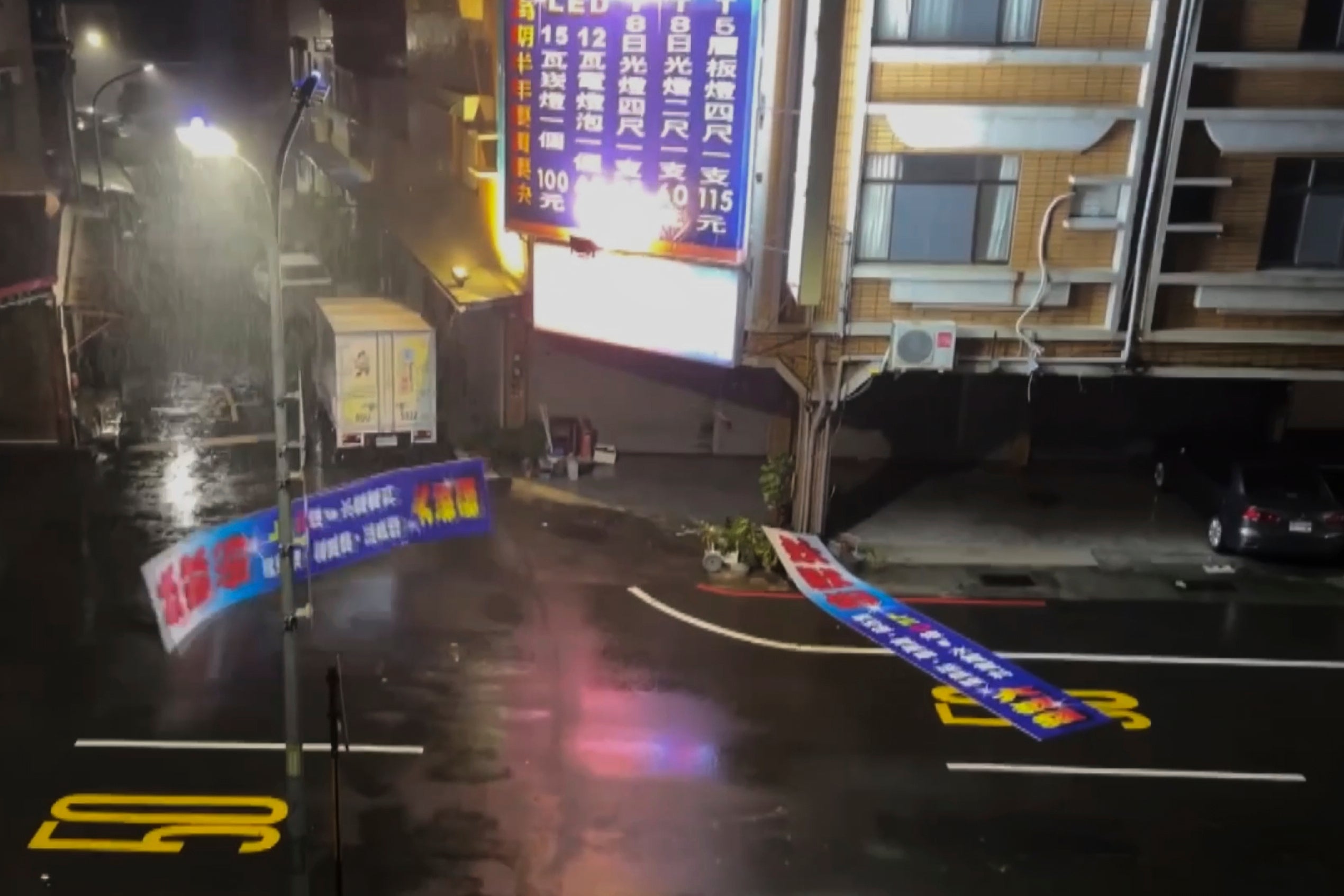 This image made from a video provided by TVBS shows damaged billboard sign on a street after the Typhoon Danas landed in Tainan, Taiwan