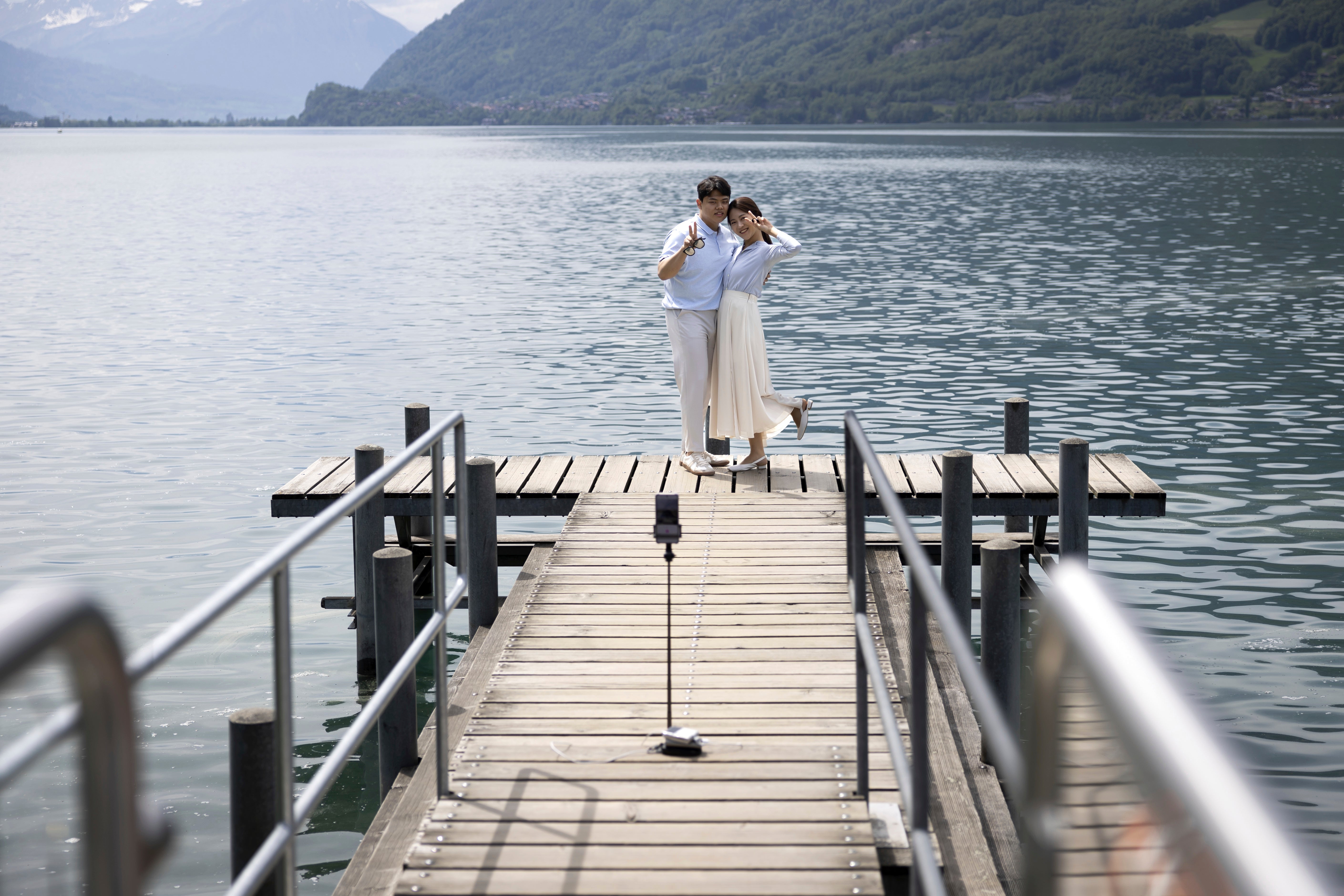 Korean visitors take pictures on the pier at Lake Brienz in Iseltwald, Switzerland, Sunday, May 21, 2023