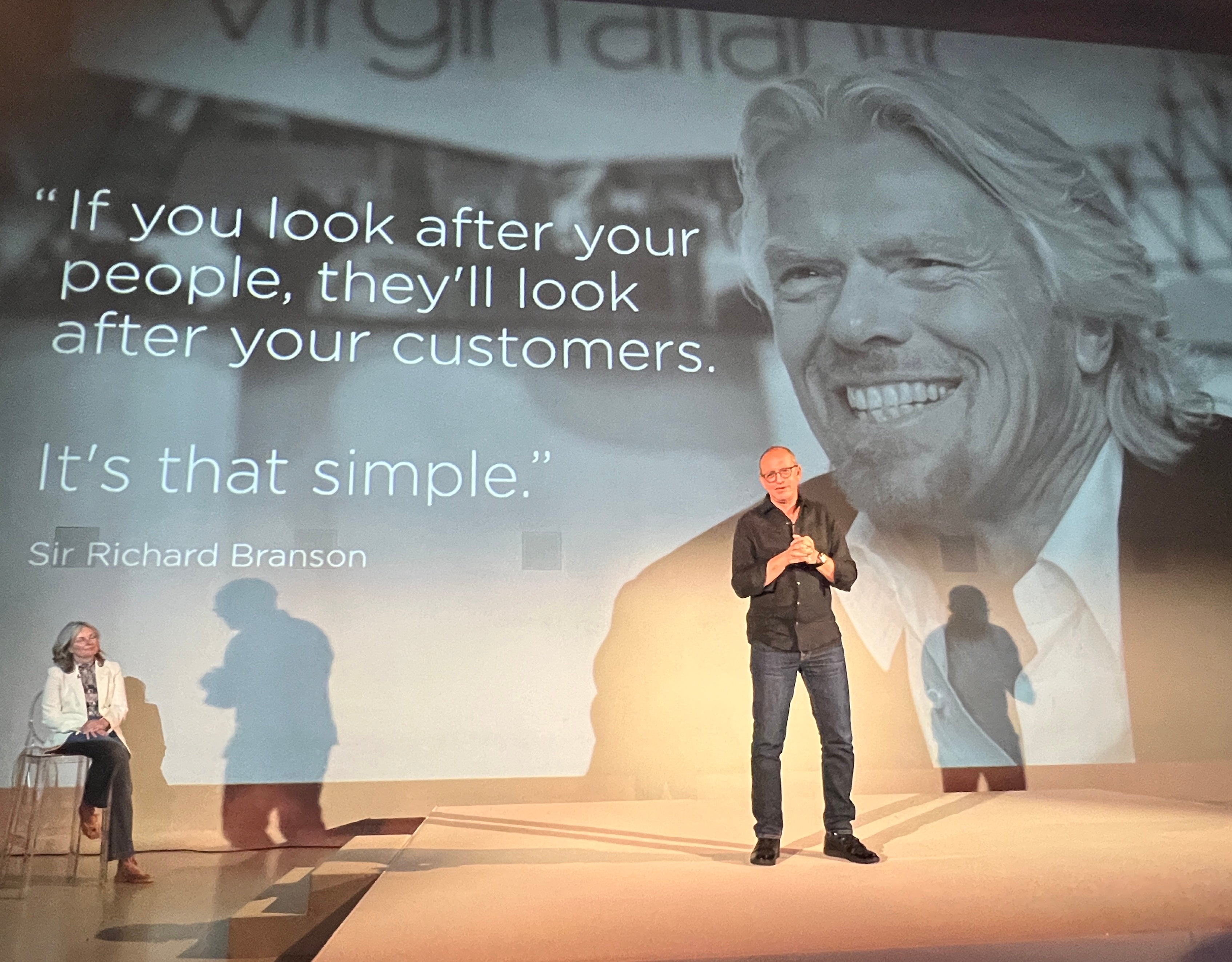 Going places: Shai Weiss, CEO of Virgin Atlantic, on stage in front of an image of airline founder Sir Richard Branson; to the left, chief experience officer, Siobhan Fitzpatrick