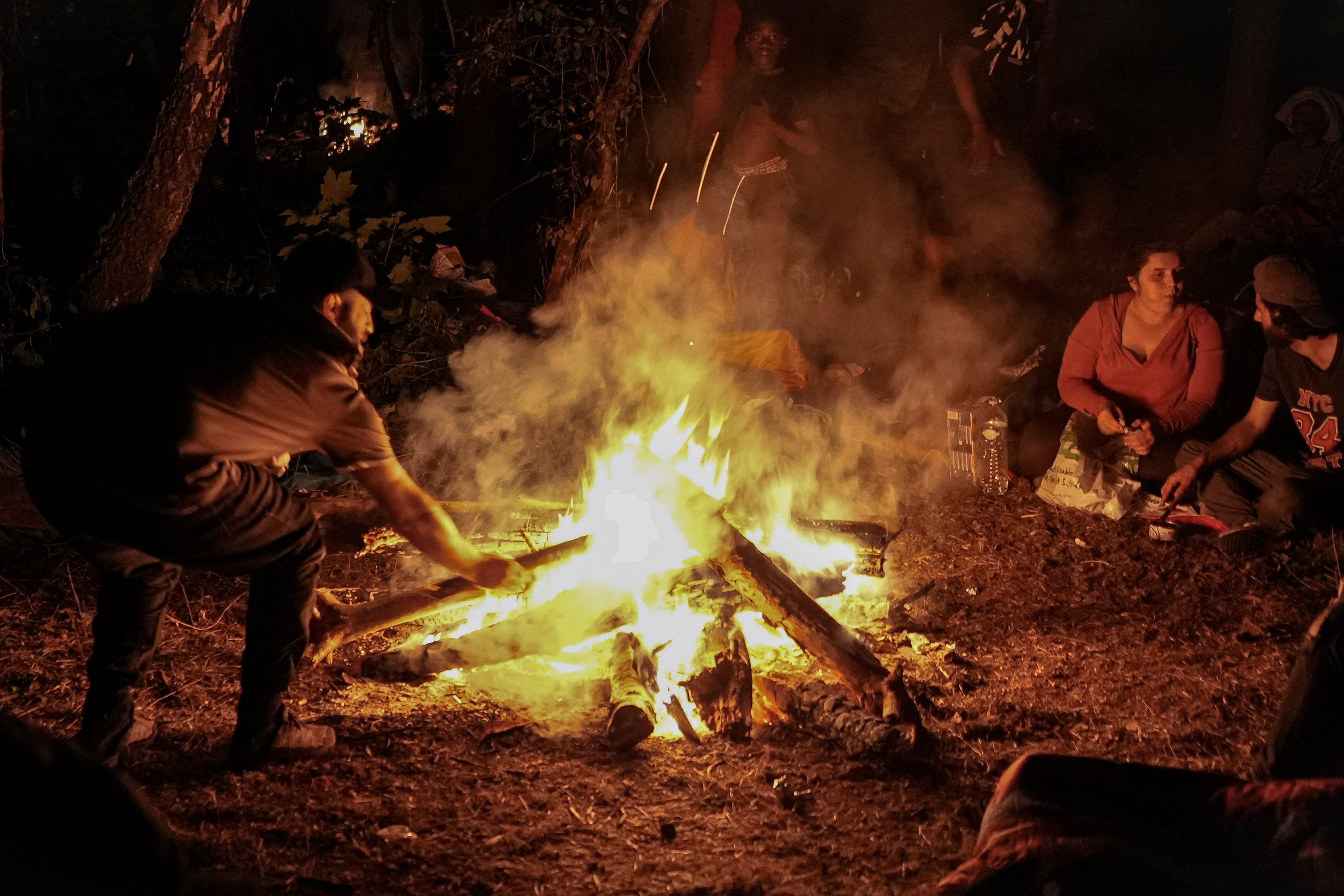 Migrants gather by a campfire in northern France