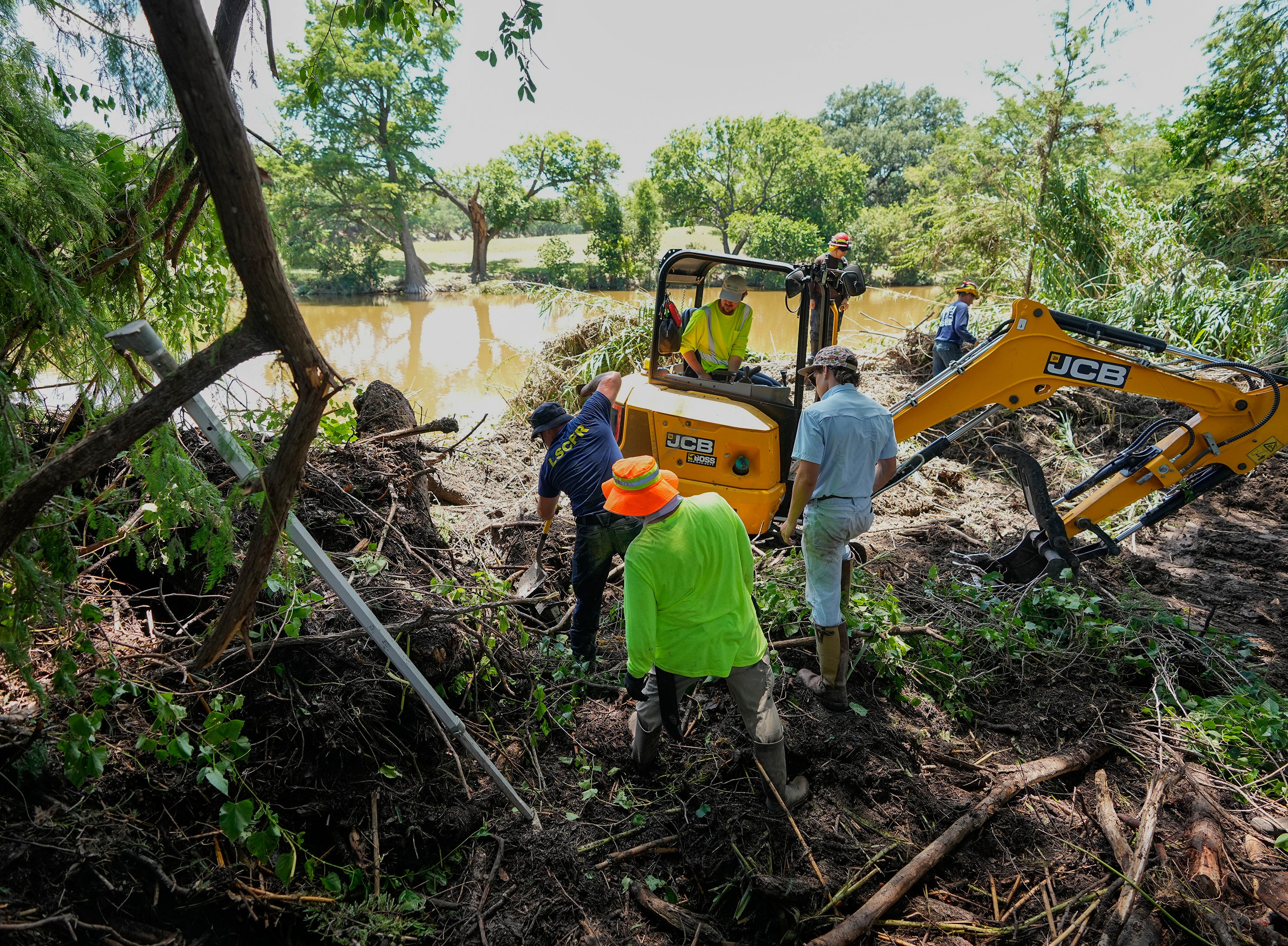 First responders and volunteers conduct search and rescue work on the banks of the Guadalupe River in Ingram, Texas after floods ravaged the region
