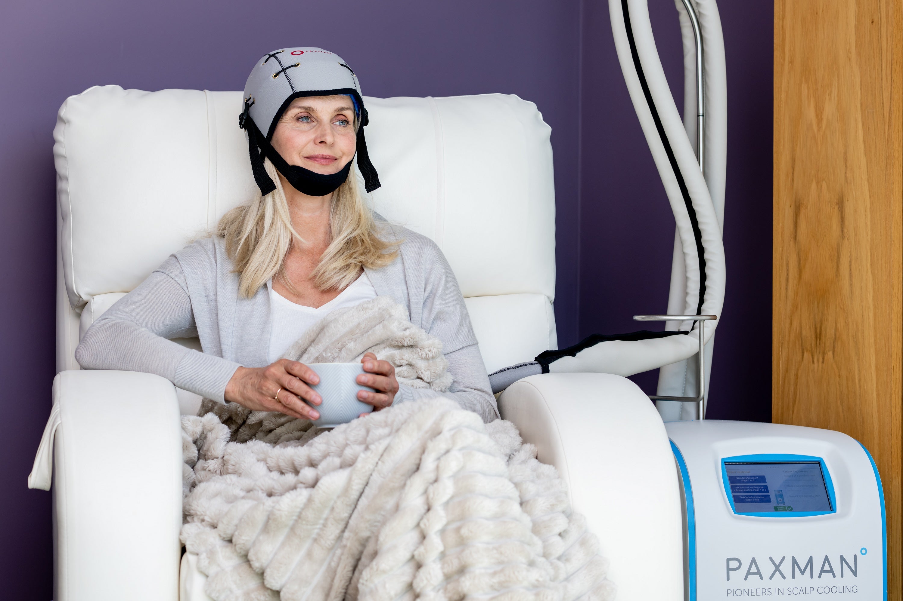A woman wearing a scalp cooling device