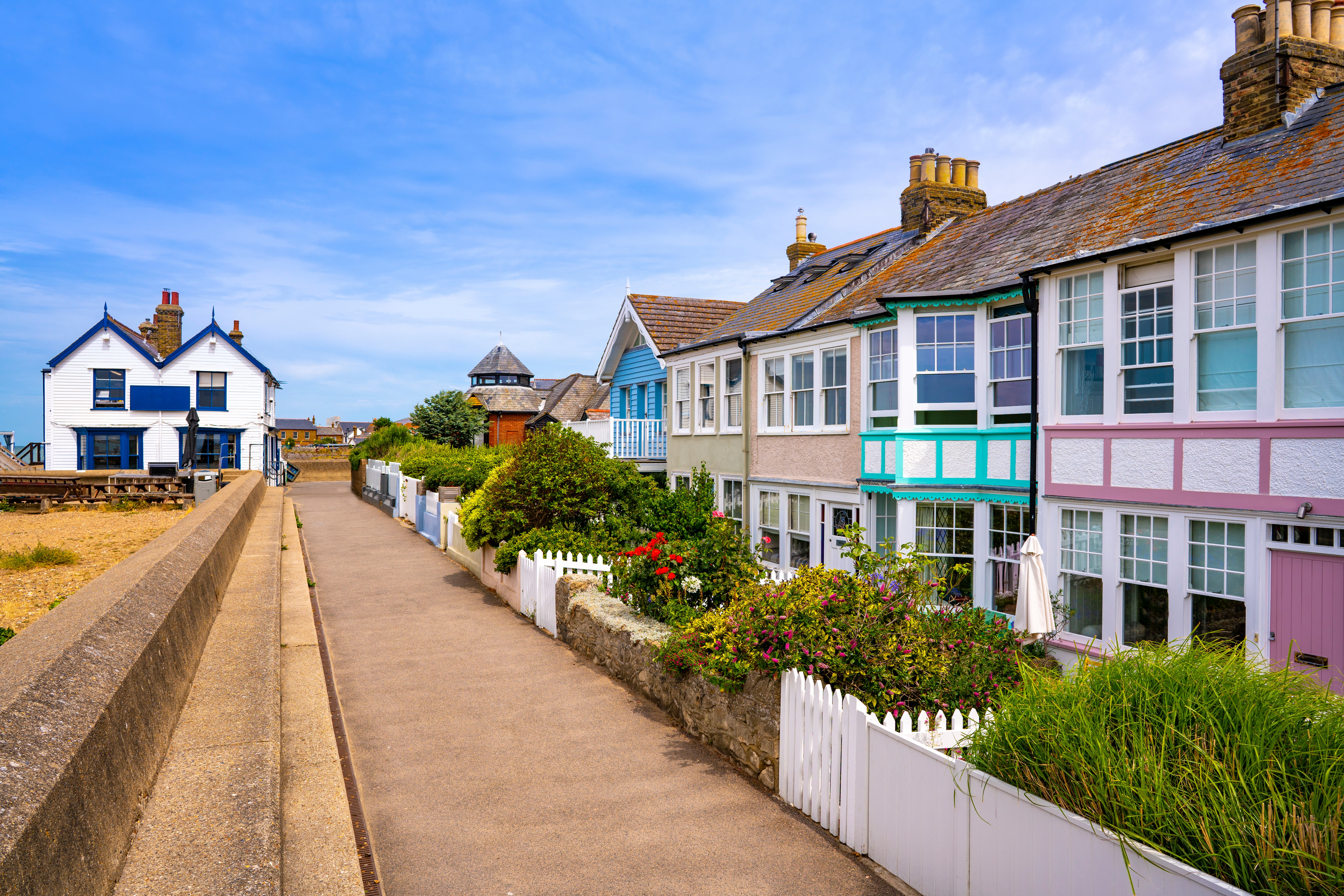 Colourful beach huts add to the vibrant atmosphere on the seafront in Whistable