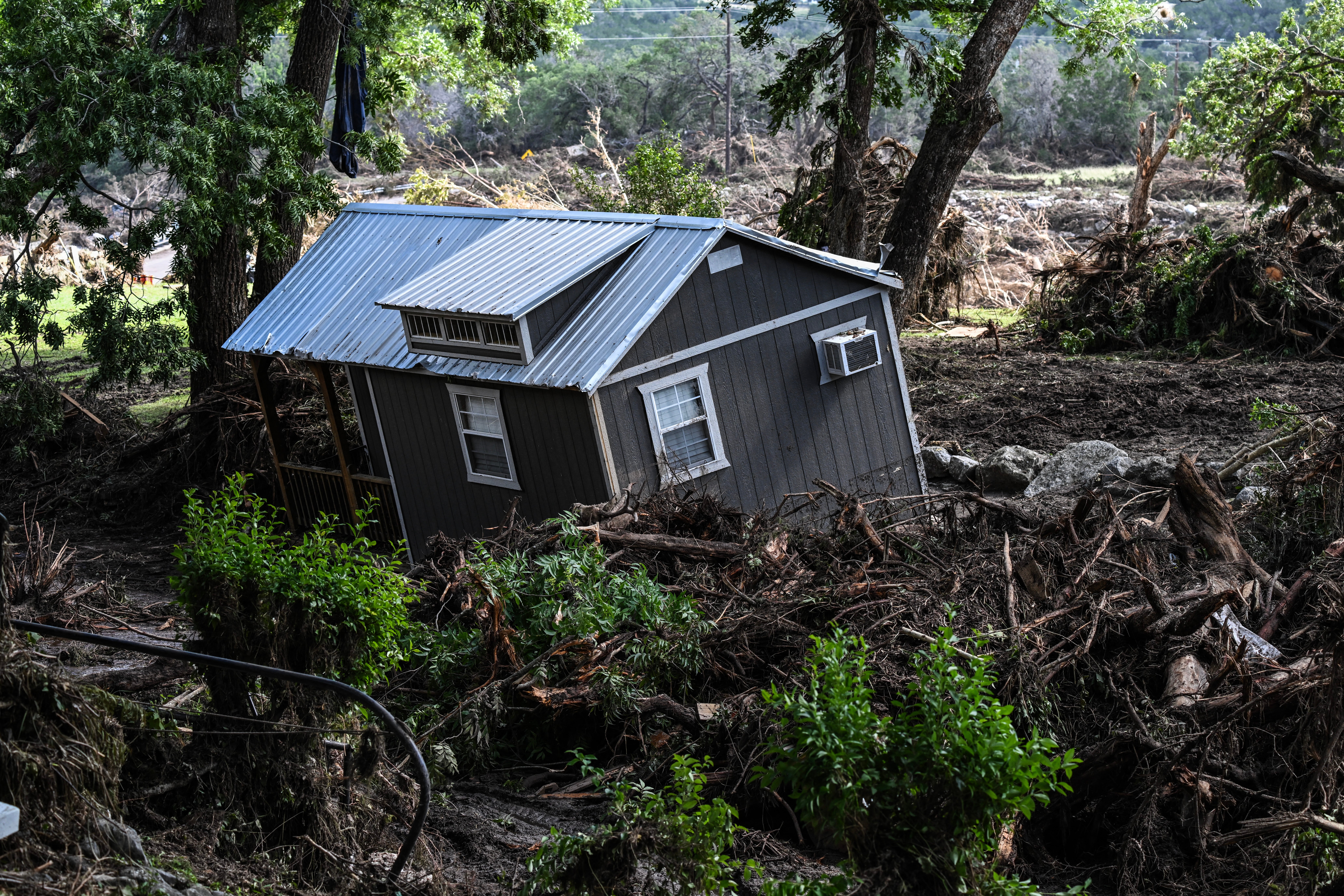 A damaged house is seen floating down the Guadalupe River in Hunt, Texas, Tuesday
