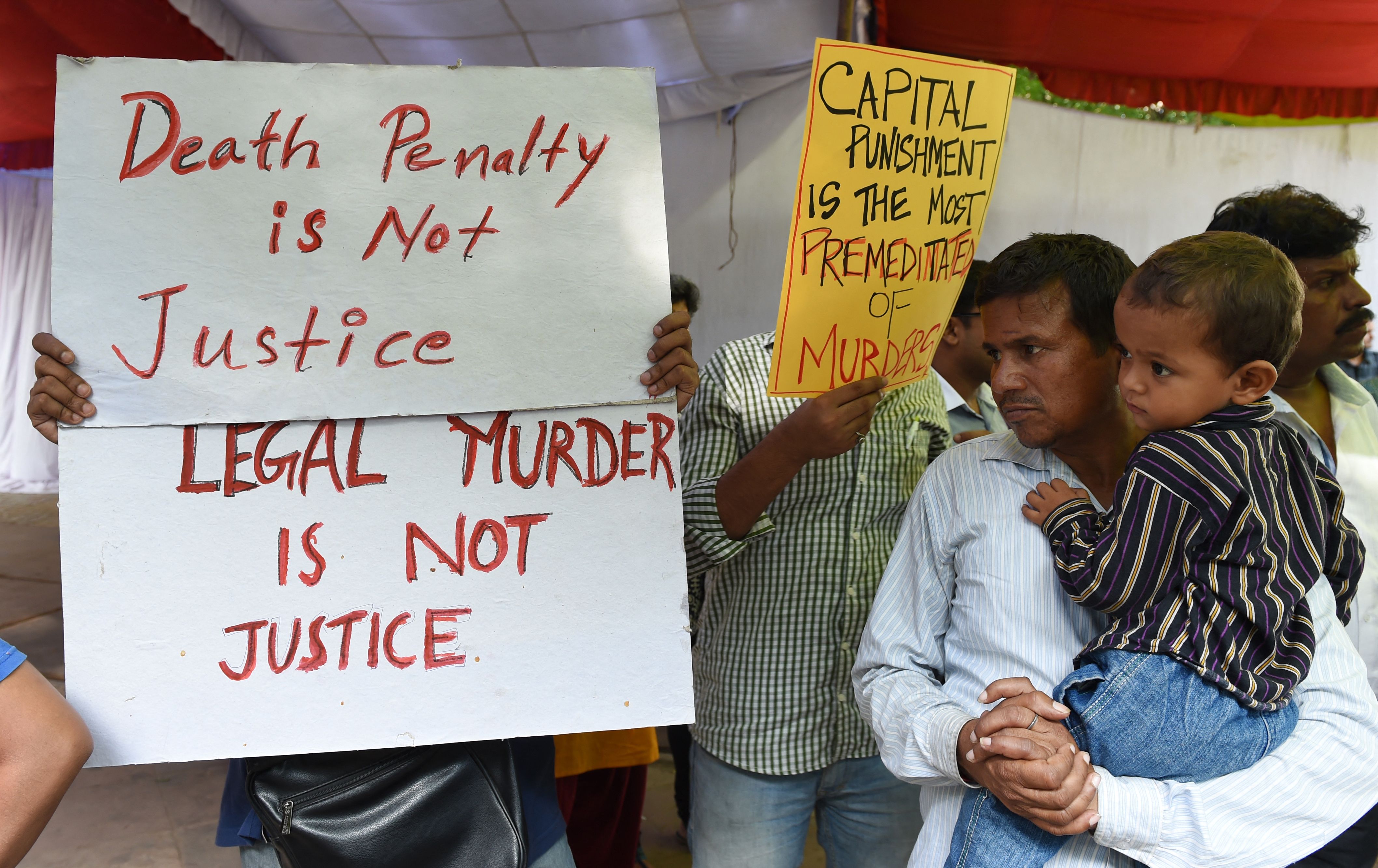 File. Indian activists hold placards during a protest against capital punishment in Delhi on 30 July 2015