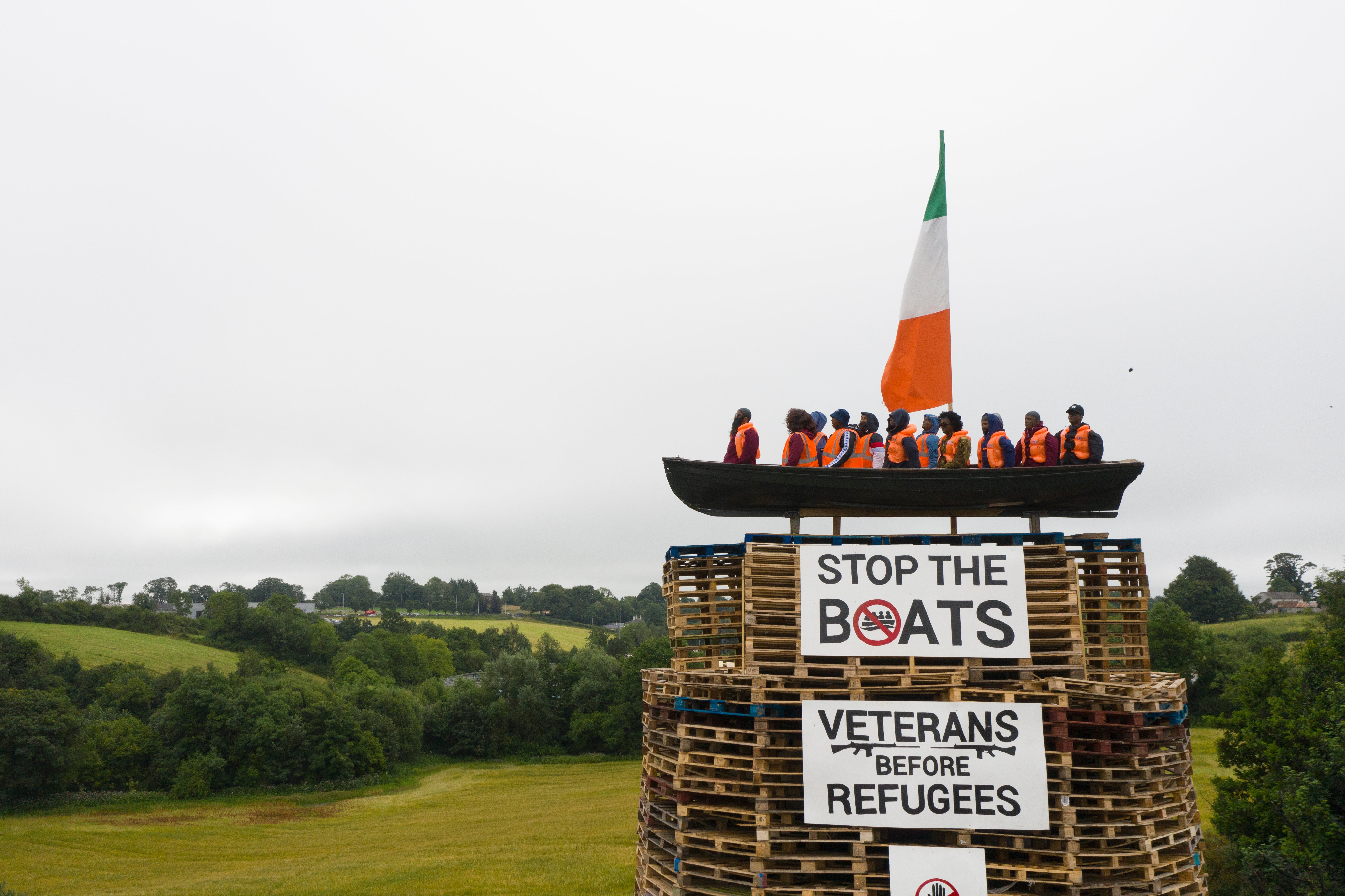 A model of a small boat with several figures depicting migrants inside can be seen on top of a loyalist bonfire
