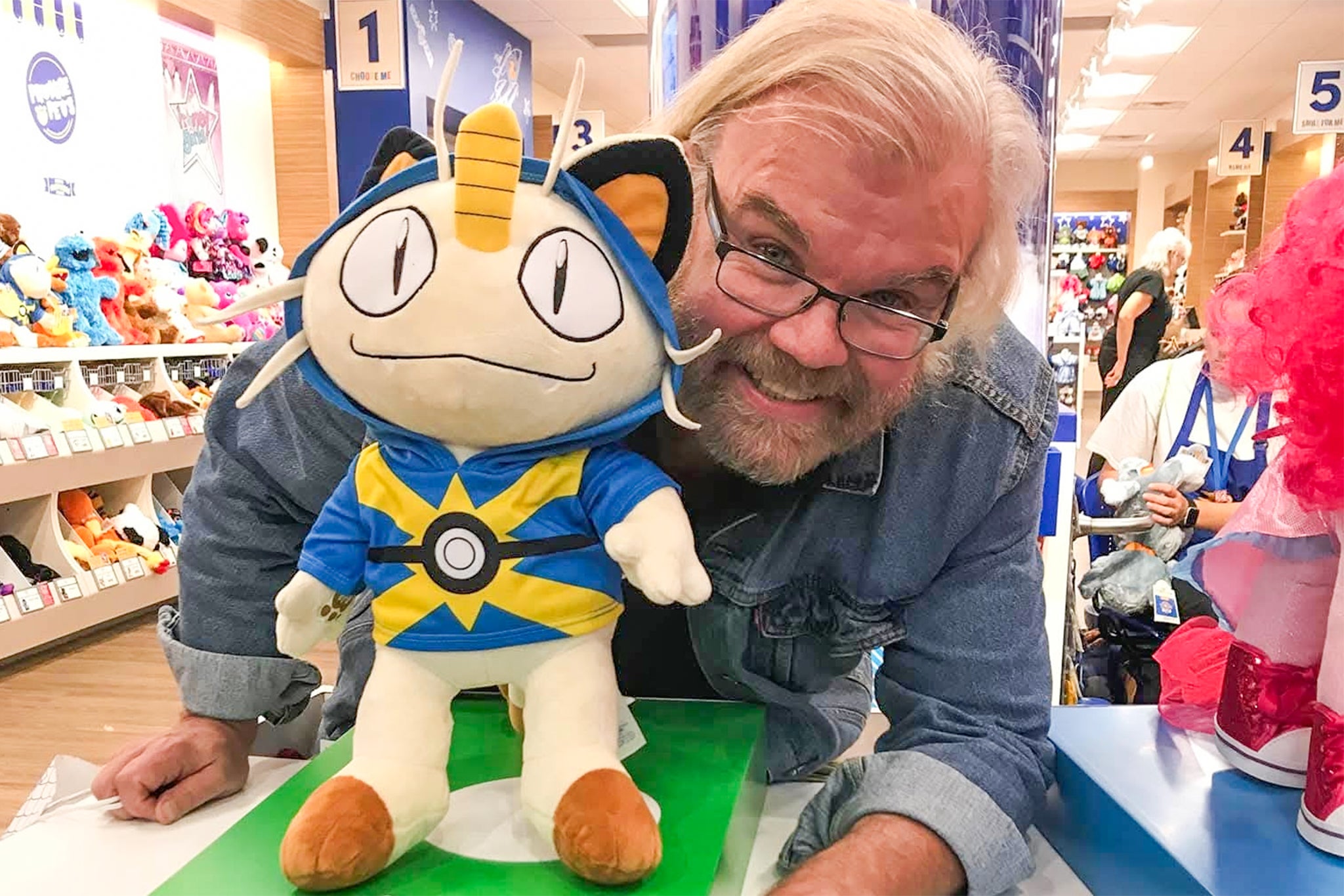 James Carter Cathcart posing with a toy of one of the ‘Pokémon’ characters he voiced, Meowth