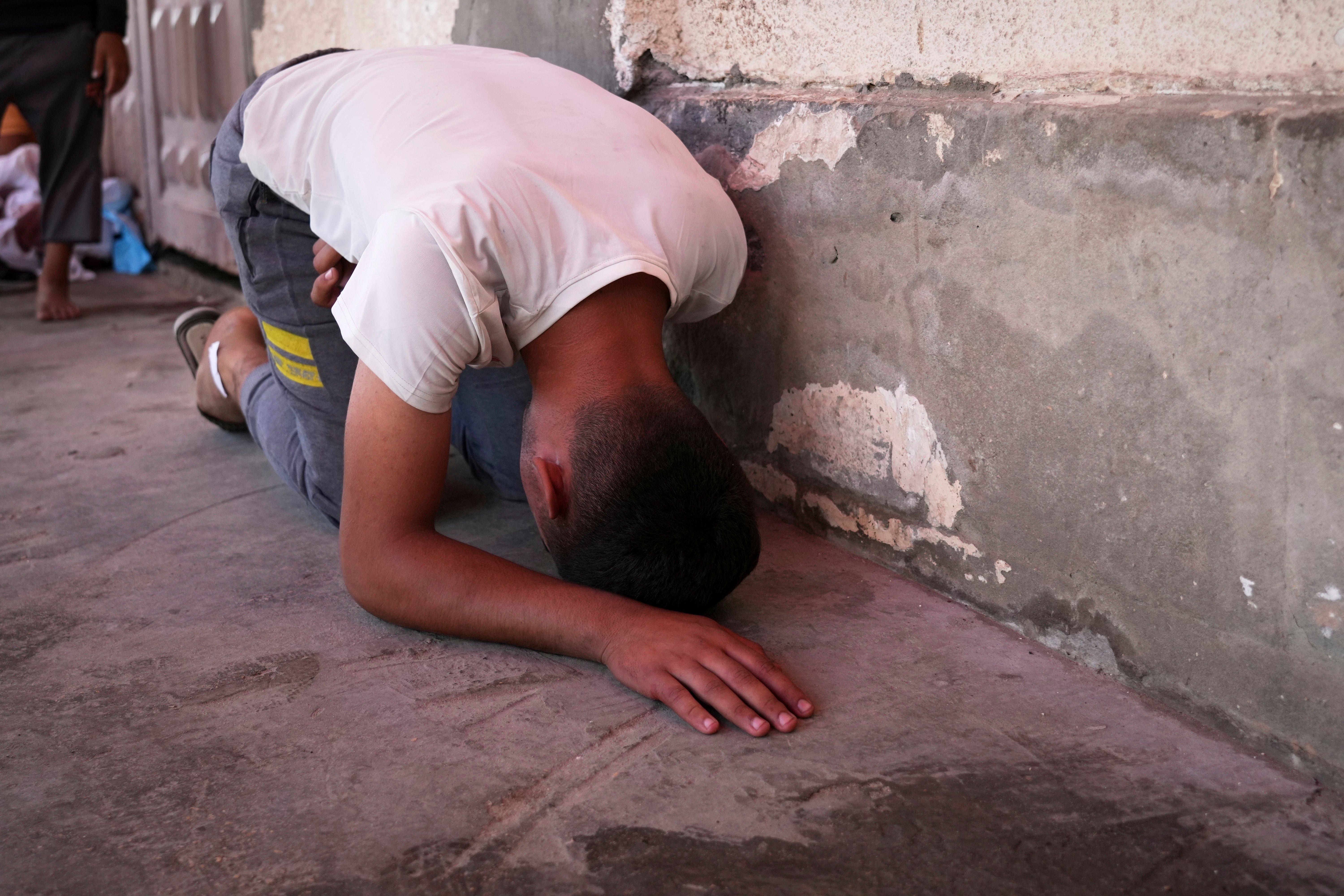 Youssef Abd Rabbo weeps at the hospital where the body of his mother Manal was taken together with 10 more people killed in an Israeli strike while they were waiting to receive nutritional supplements at the Project Hope-run medical clinic