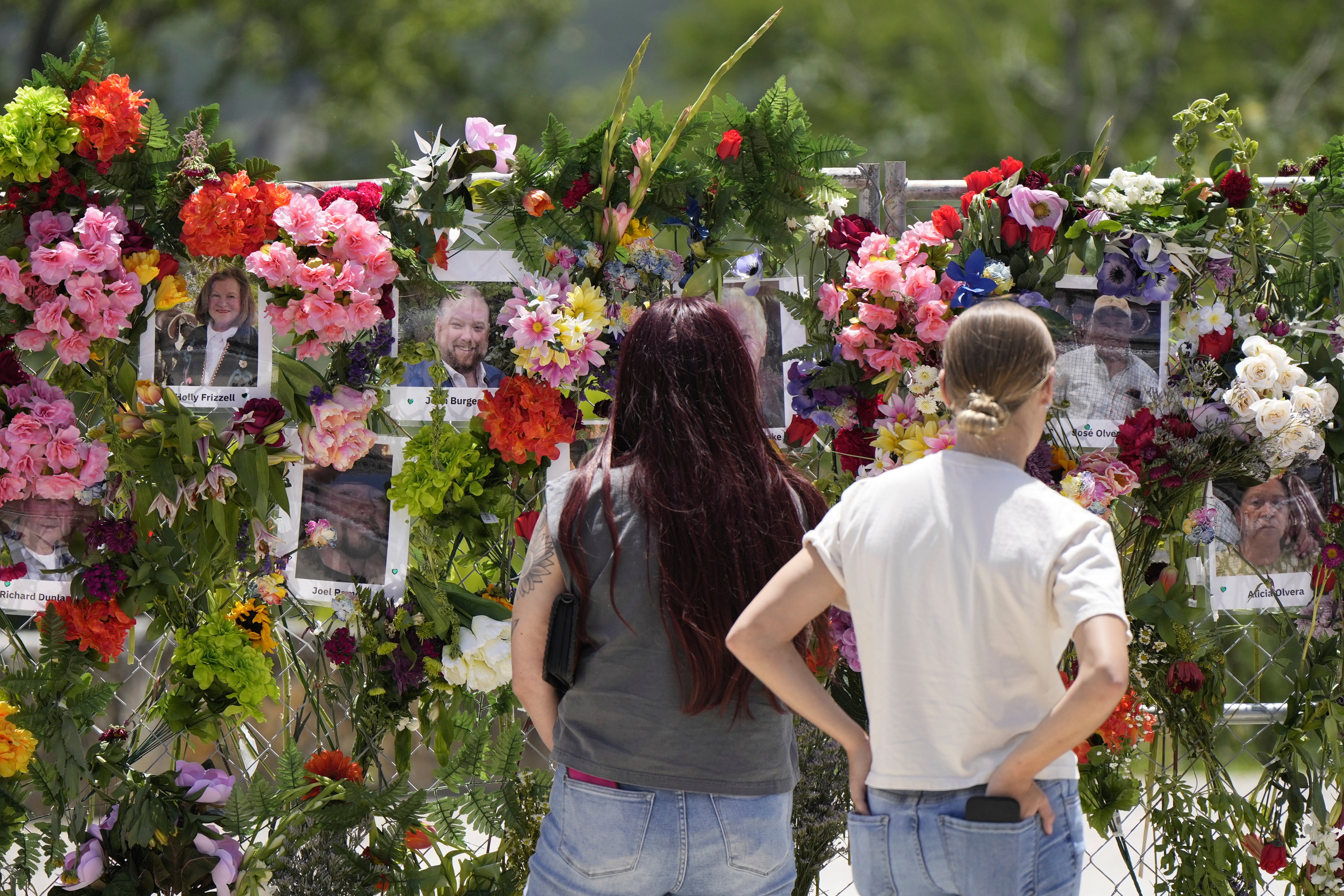 People view photos of flood victims posted on a memorial wall in Kerrville. There are still 173 people missing in central Texas