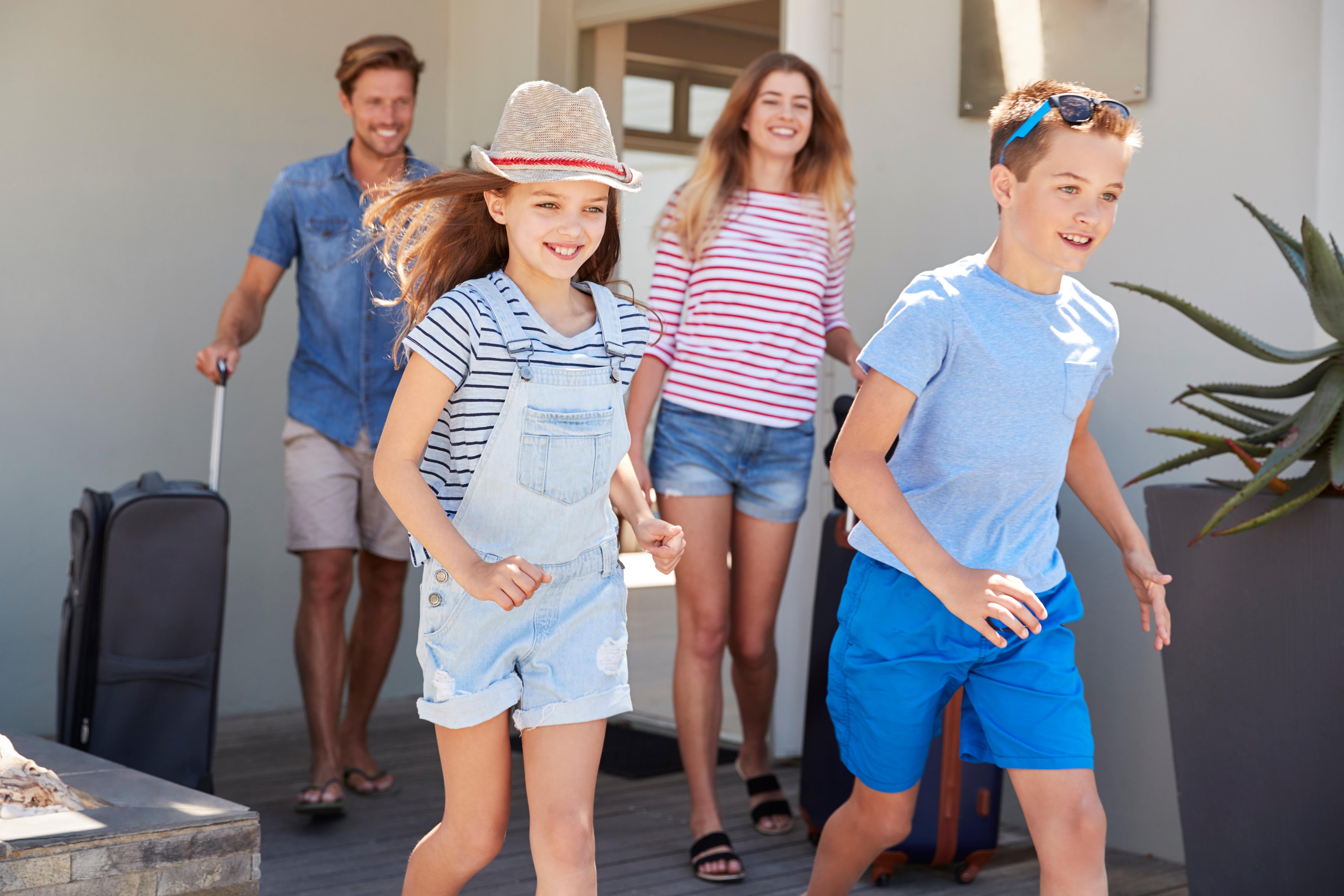 Family With Luggage Leaving House For Vacation