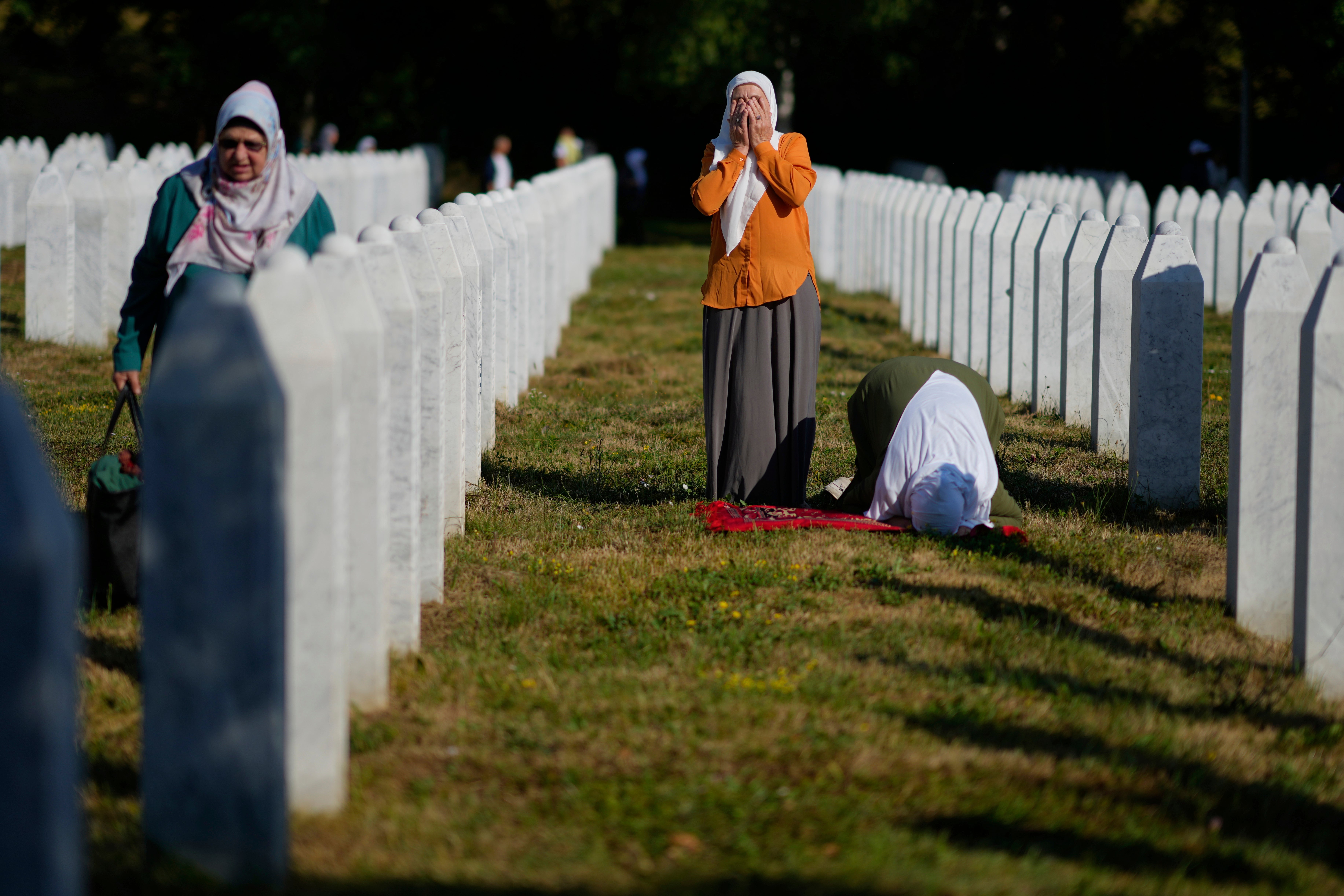 Women pray at the Memorial Center for victims of the Srebrenica genocide in Potocari, Bosnia, Friday, July 11, 2025. (AP Photo/Darko Bandic)