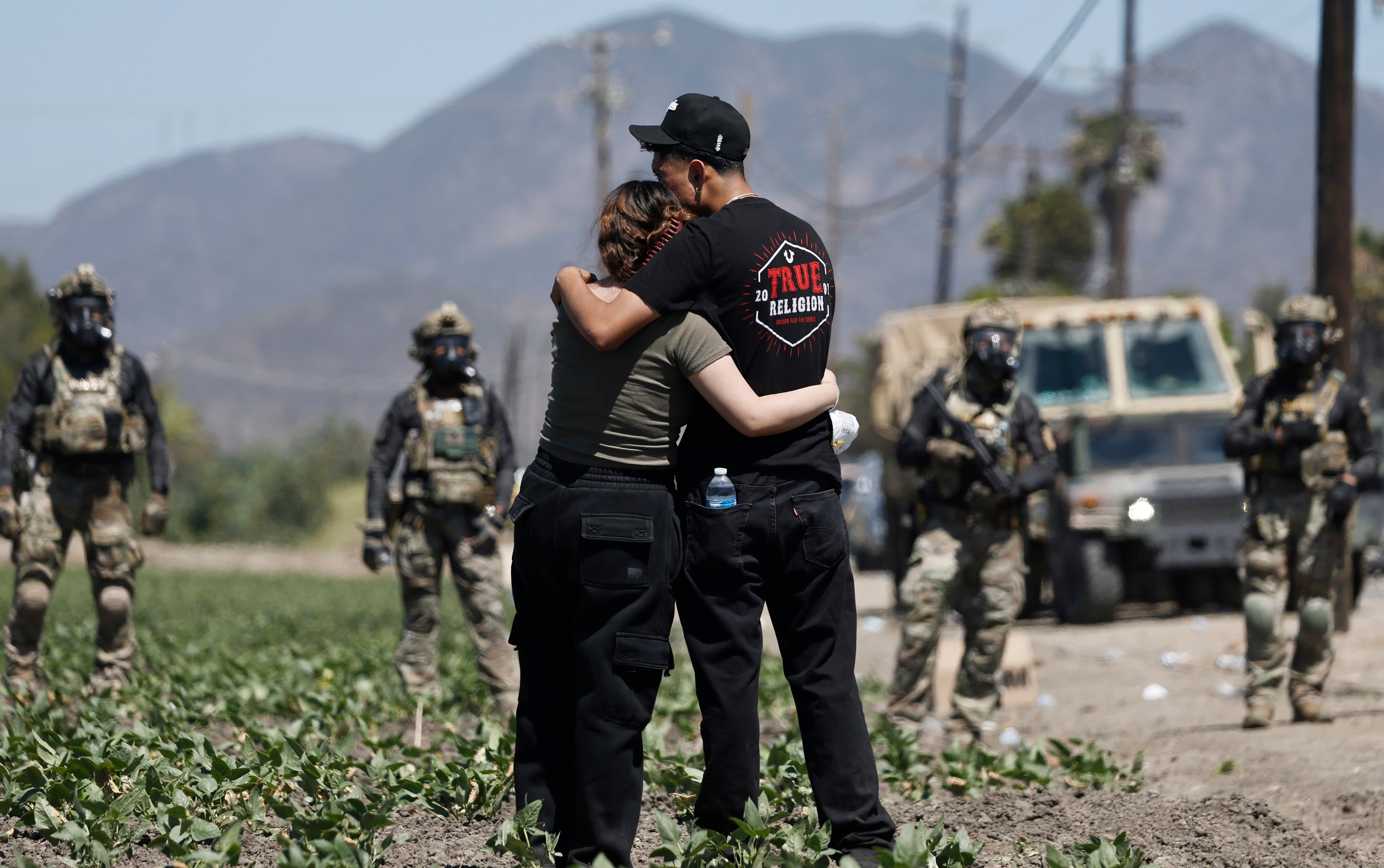 A couple cling to each other as ICE agents stand by in Camarillo last Thursday