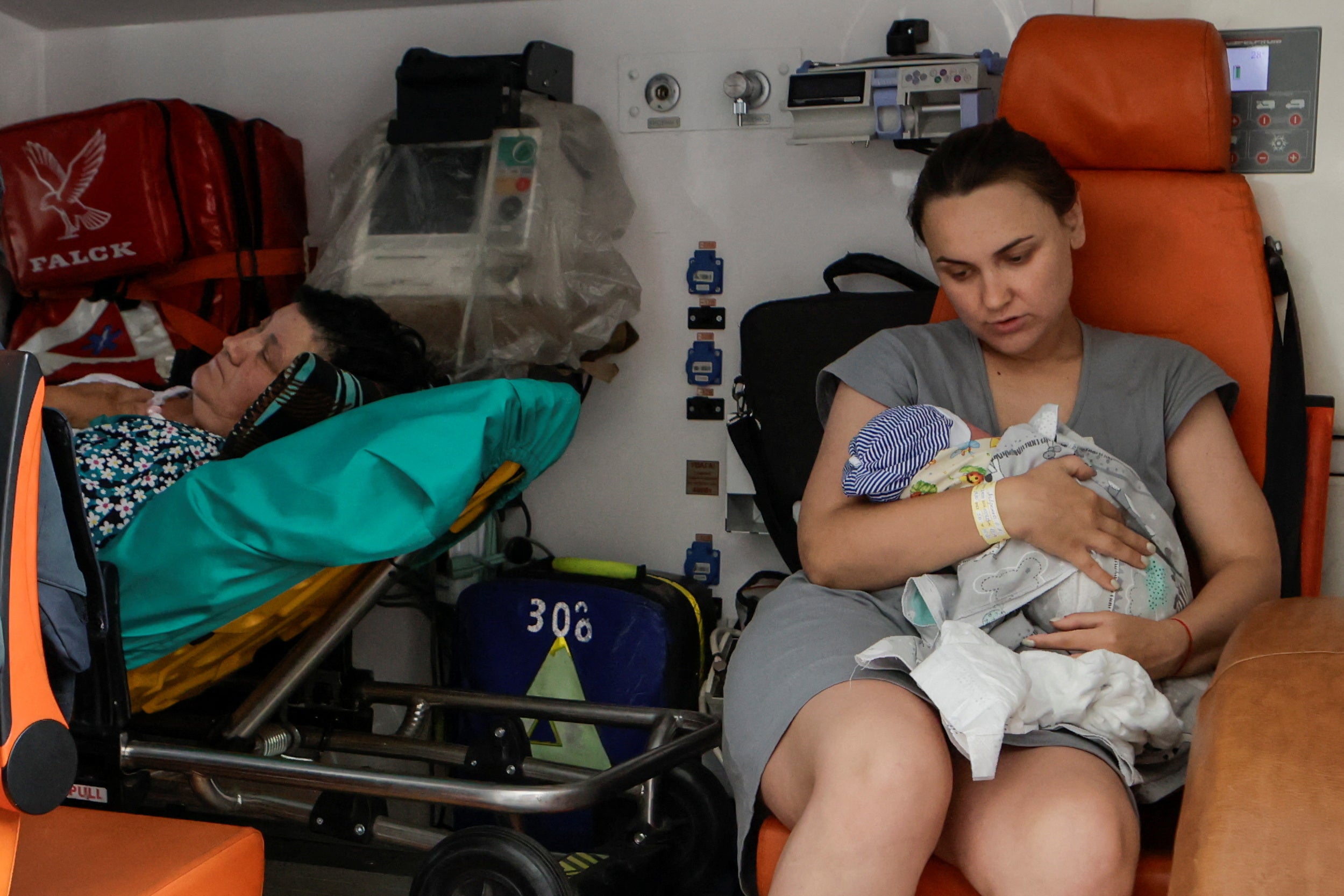 A mother holds her baby during an evacuation from a maternity hospital damaged by a Russian drone strike on Kharkiv